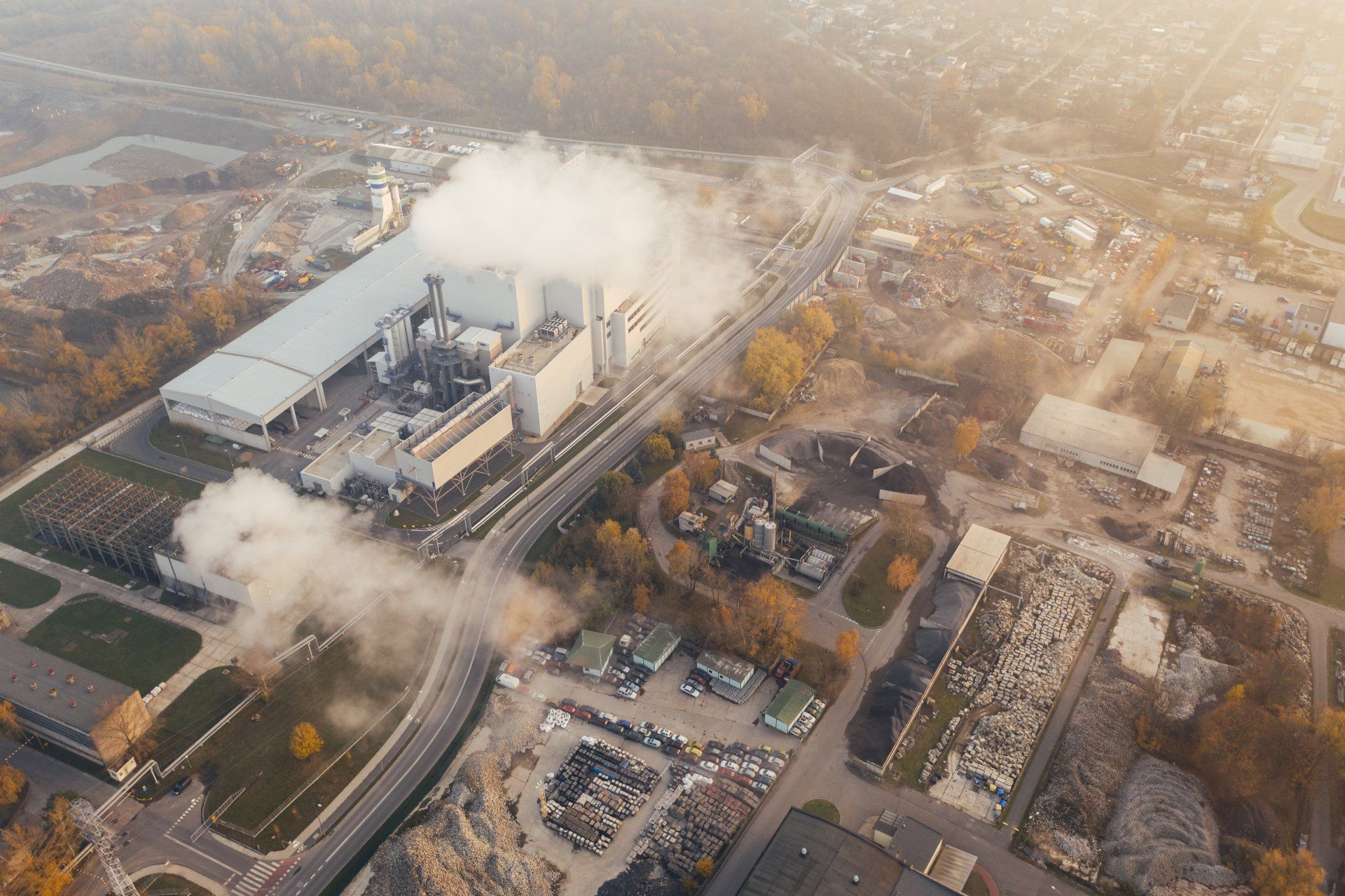 An aerial view of a factory with smoke coming out of it.