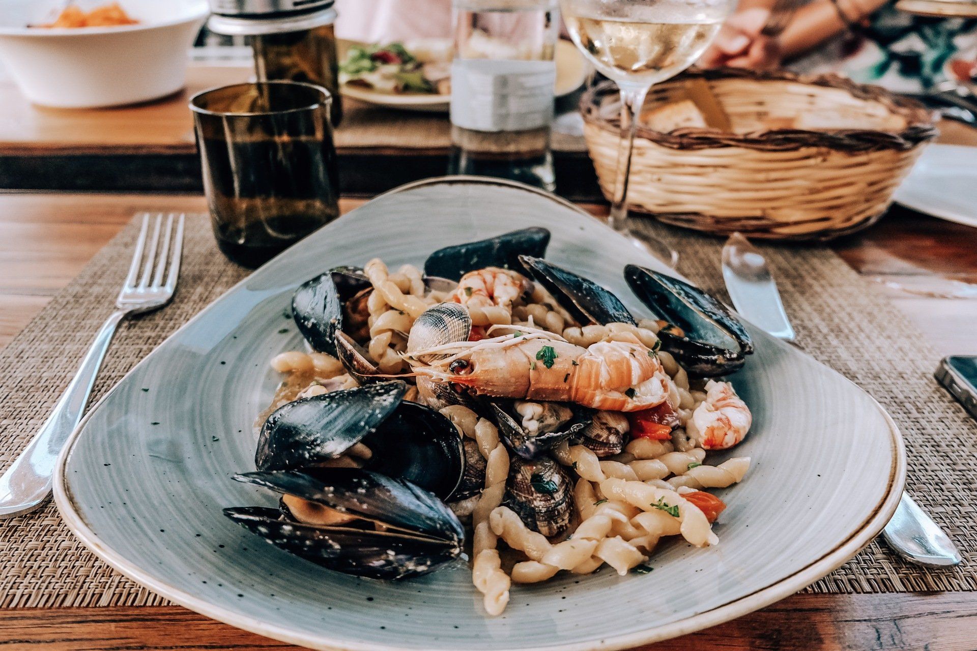 A plate of pasta with mussels and shrimp on a table.
