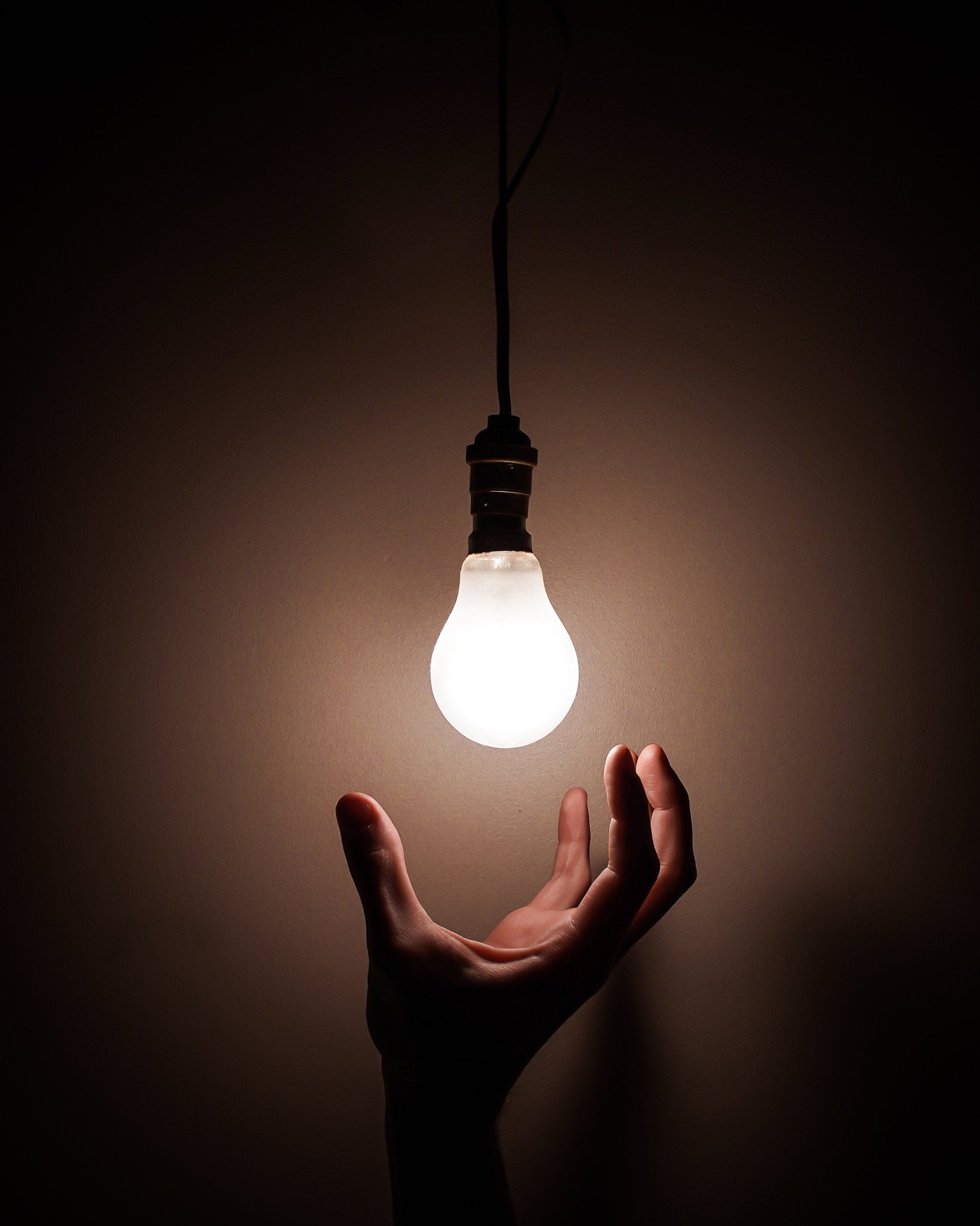 a hand below a bulb