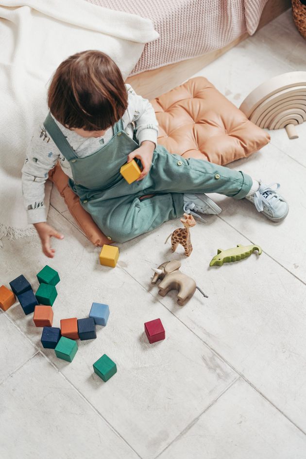 A little boy is sitting on the floor playing with toys.