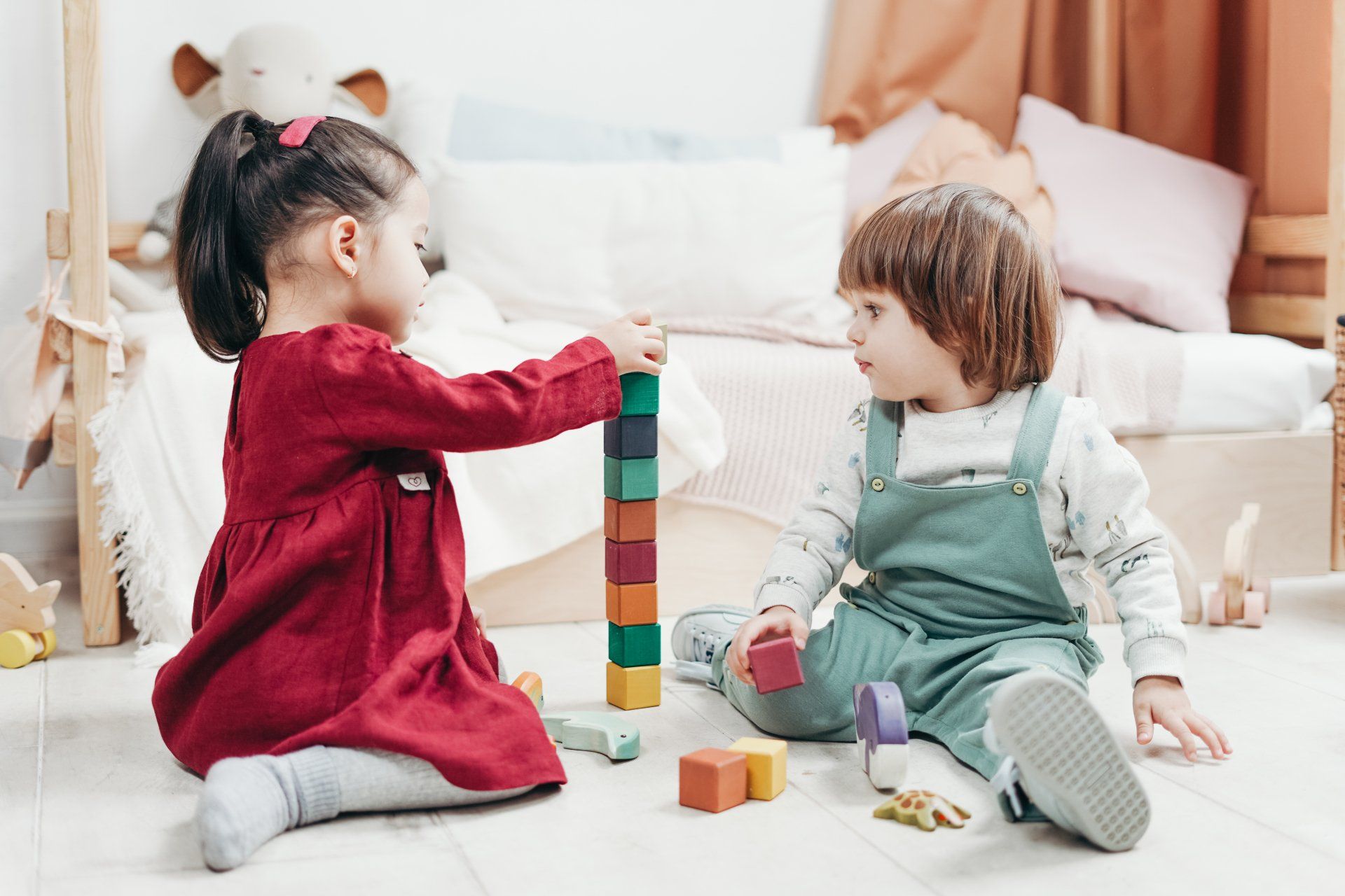 A little boy and girl playing with wooden blocks