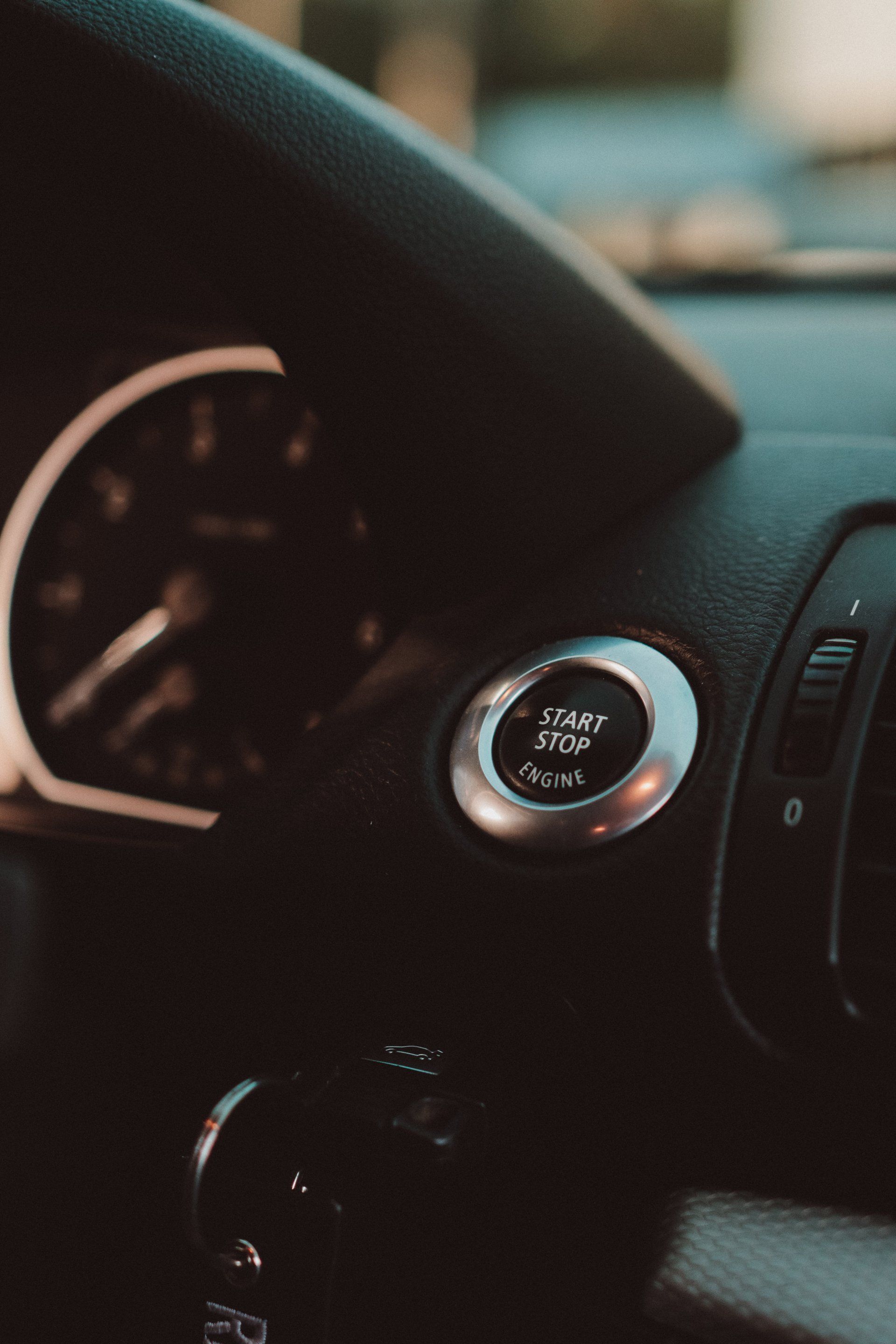 A close up of a car dashboard with a start button.