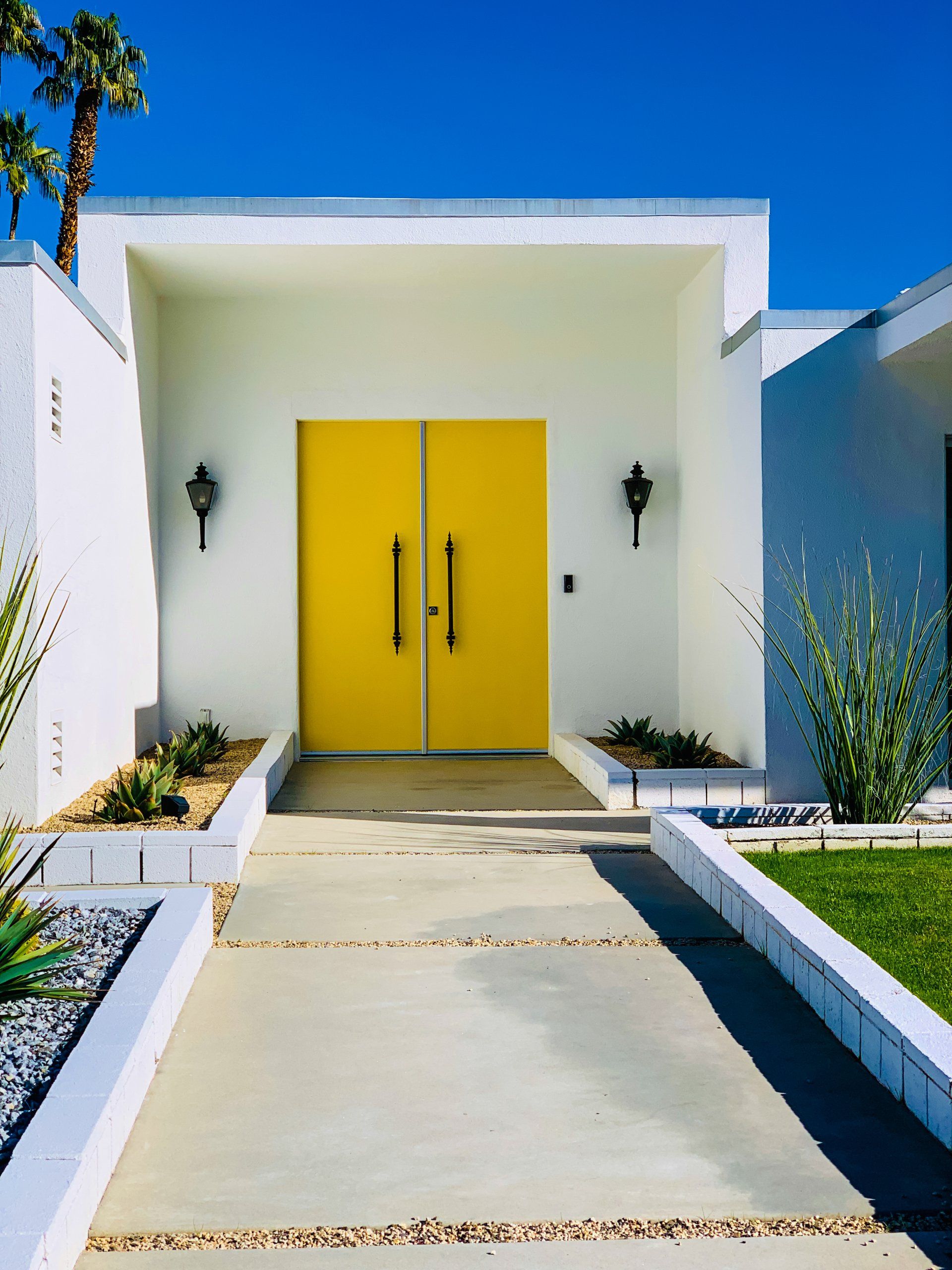 A white house with a bright yellow door