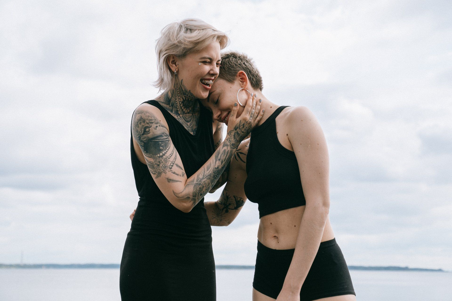 deux femmes avec des tatouages se tiennent l' une à côté de l' autre