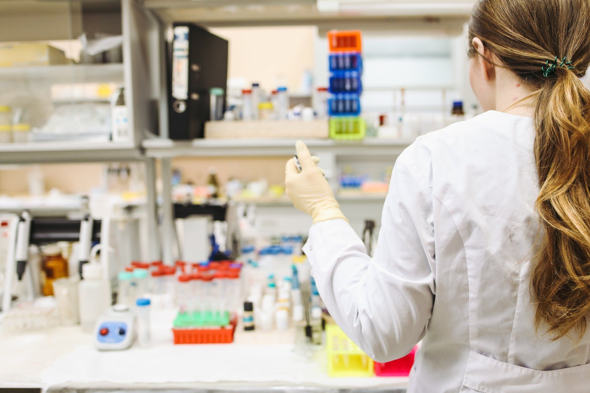 a female scientist is looking at a test tube in a laboratory .