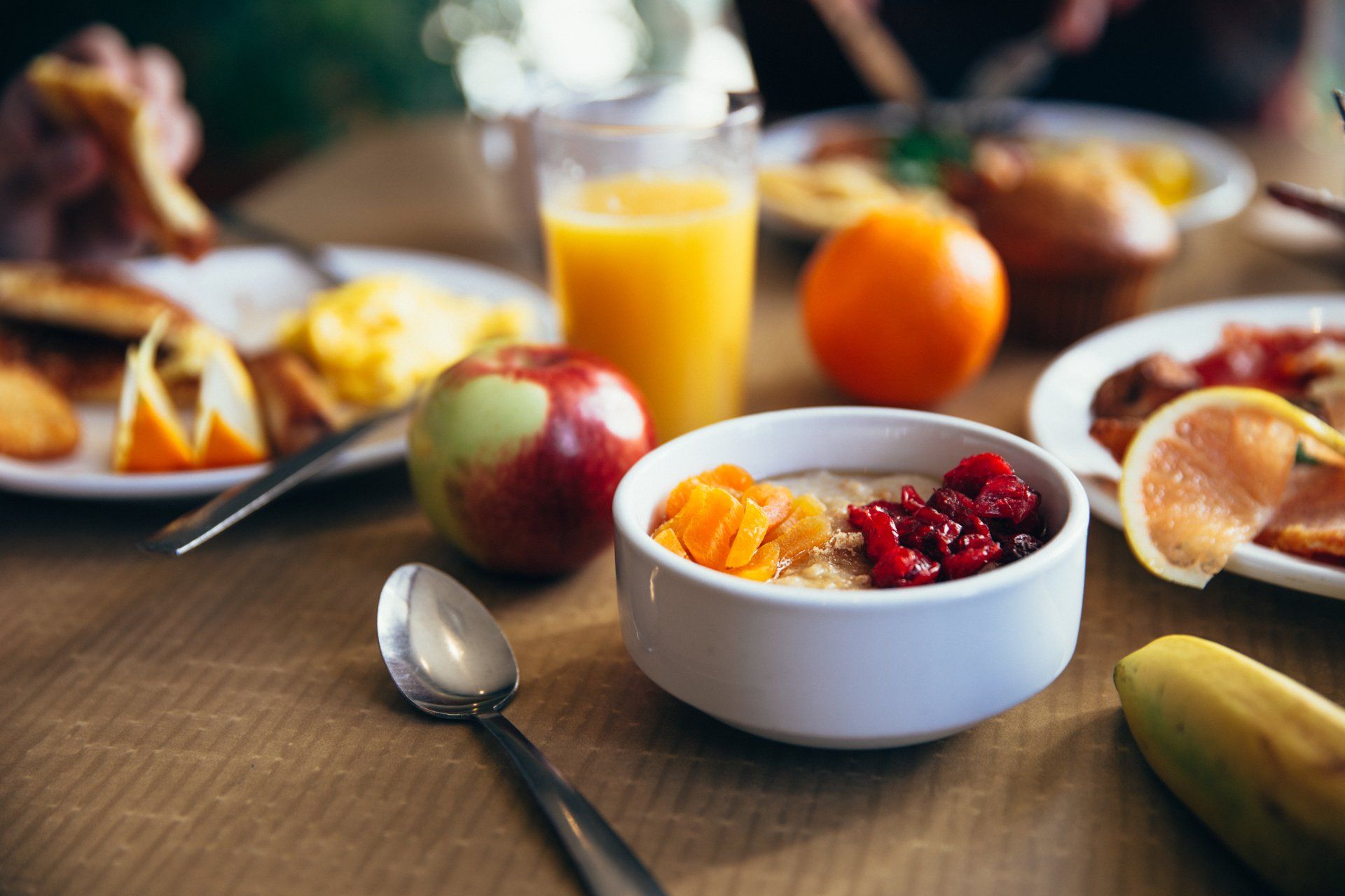 A table topped with plates of food and a bowl of cereal.