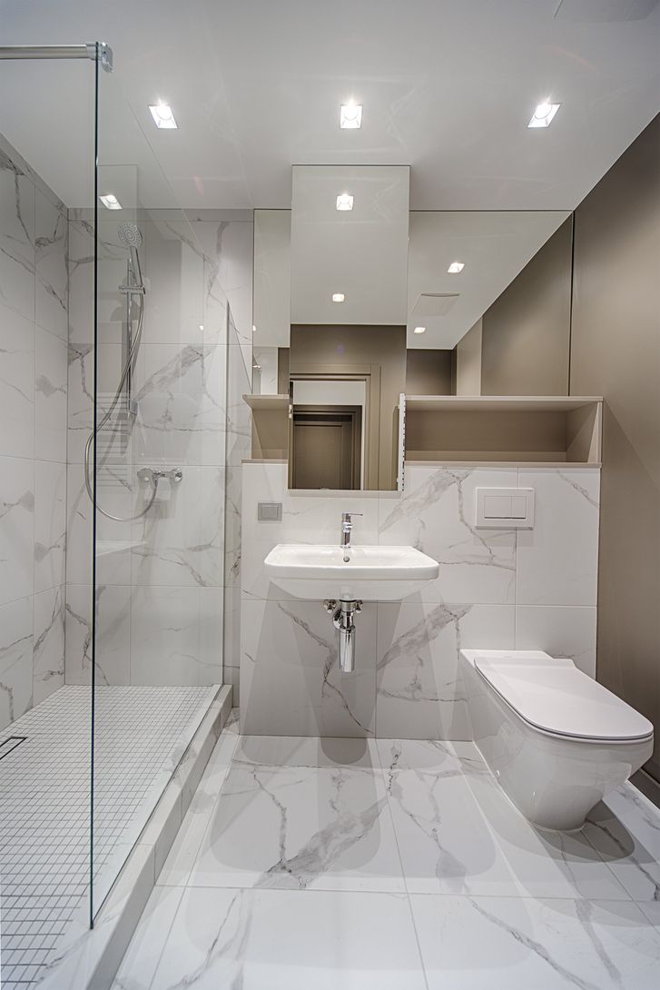 A bathroom with a sink , toilet , shower and mirror.