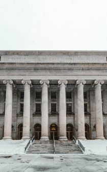 A large building with columns and stairs in front of it.