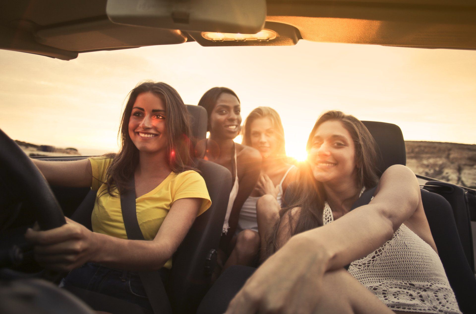 A group of young women are sitting in a car.