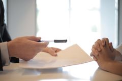 A man is giving a piece of paper to a woman.