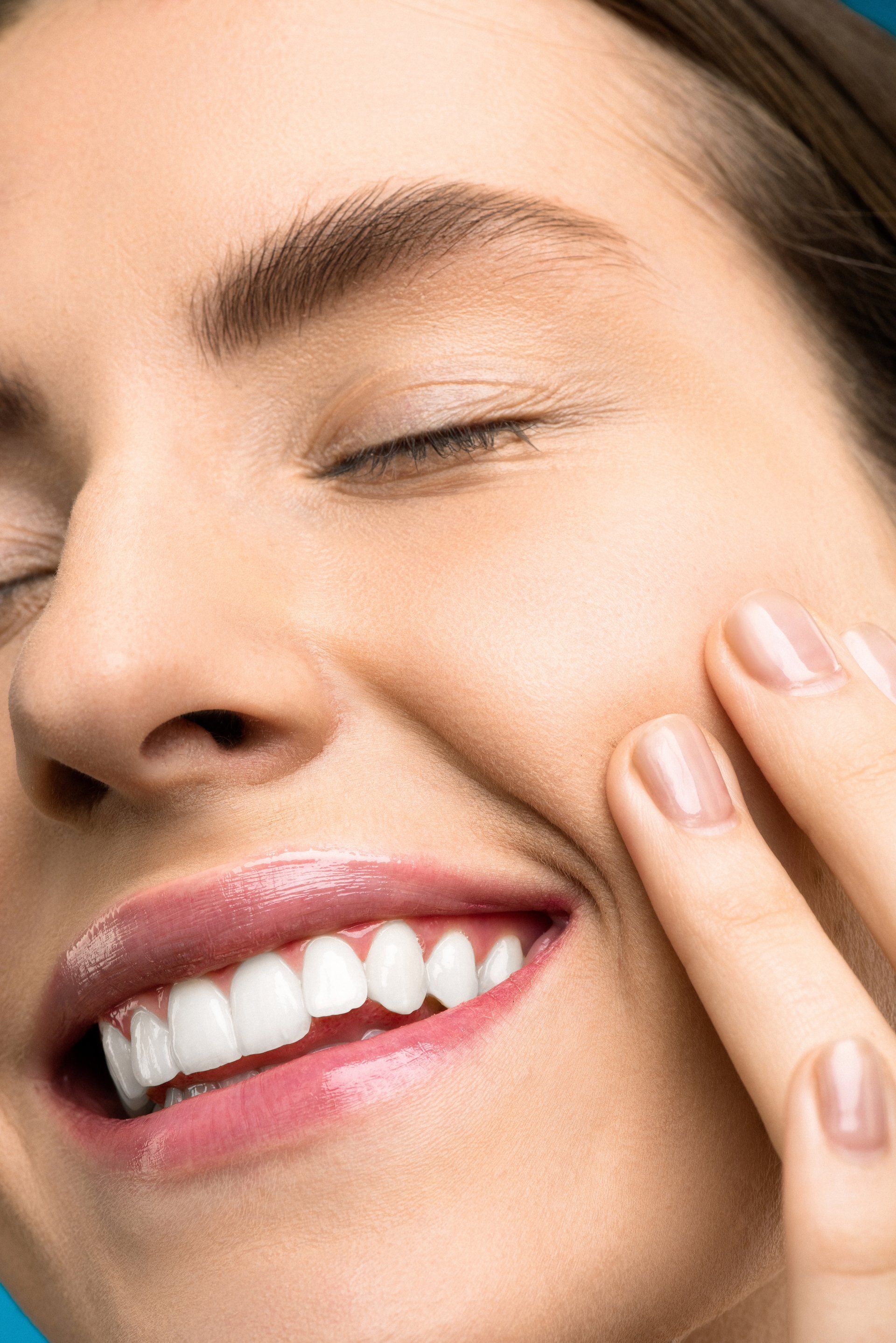 woman smiling holding cheek | Dentist Prosper TX
