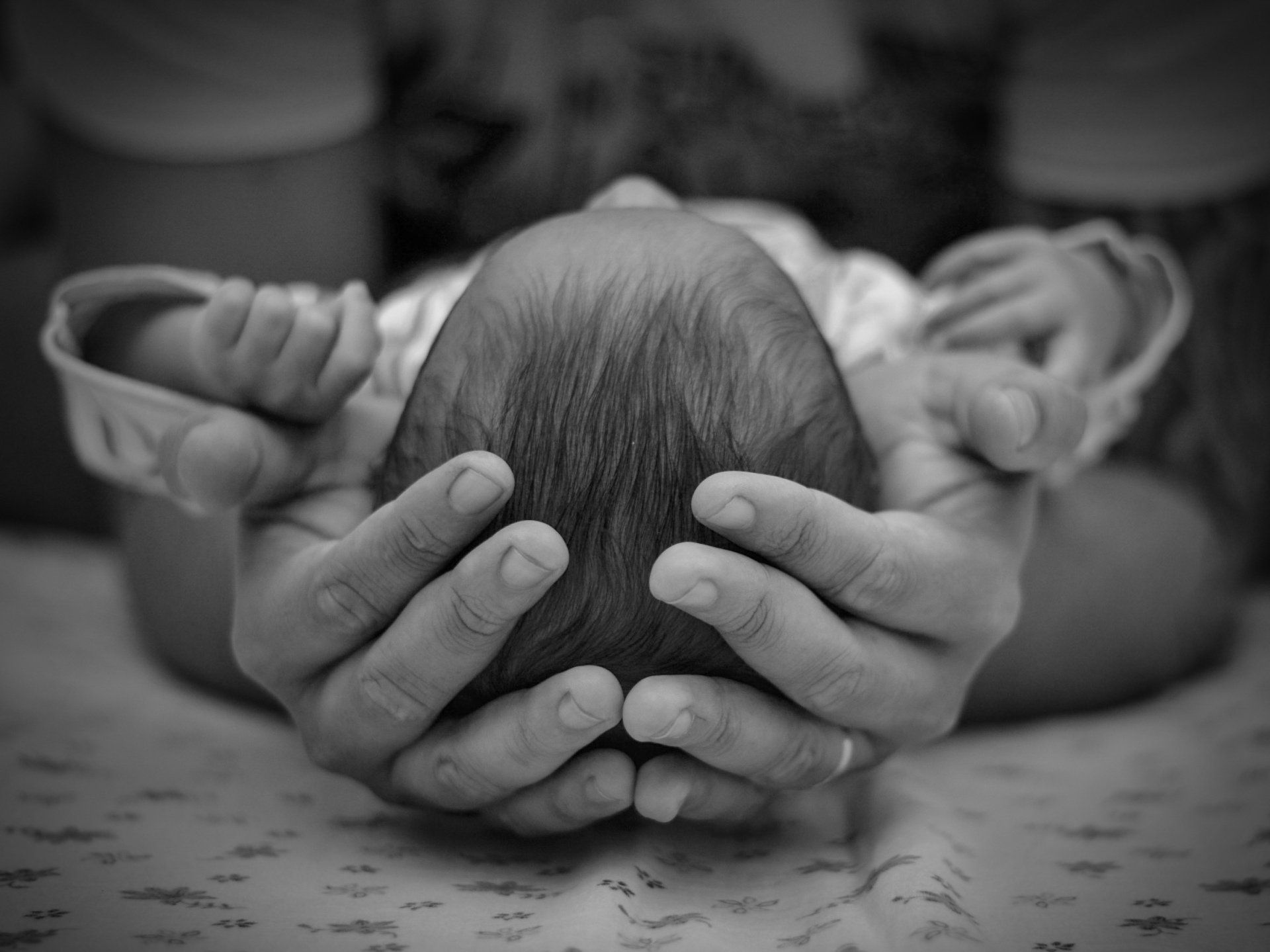 Parent cradling head of an infant