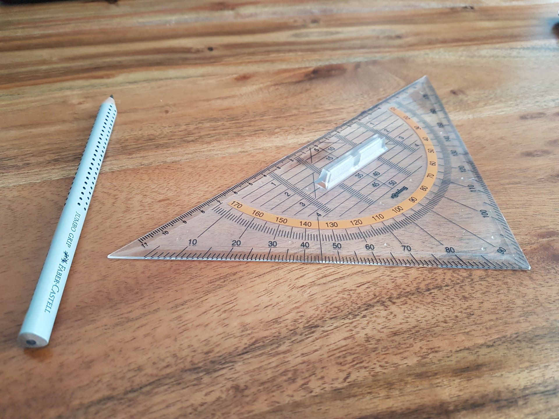 A ruler and pencil are on a wooden table