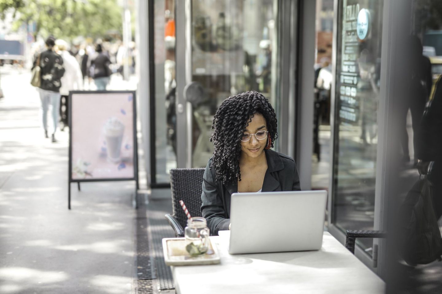 A woman is sitting at a table using a laptop computer.