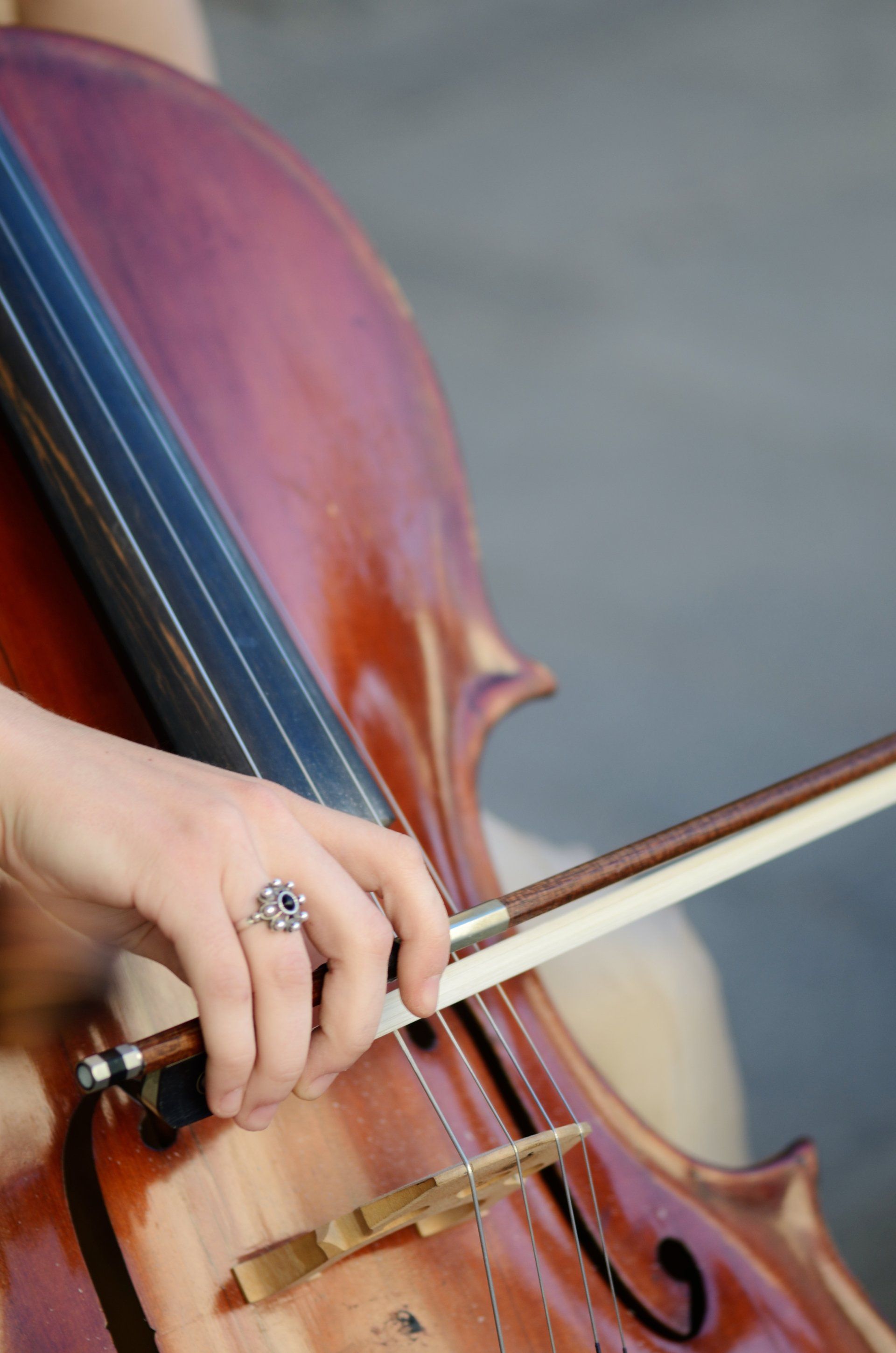 A person is playing a cello with a ring on their finger