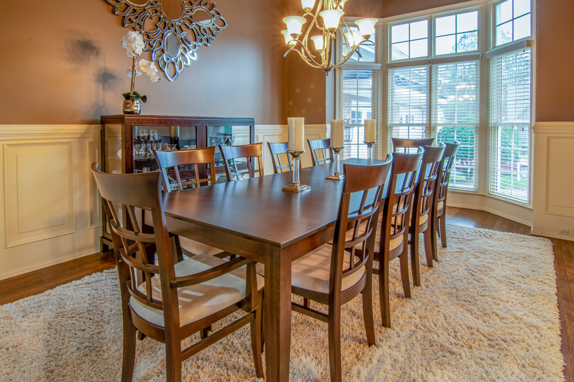 A dining room with a long table and chairs and a chandelier.