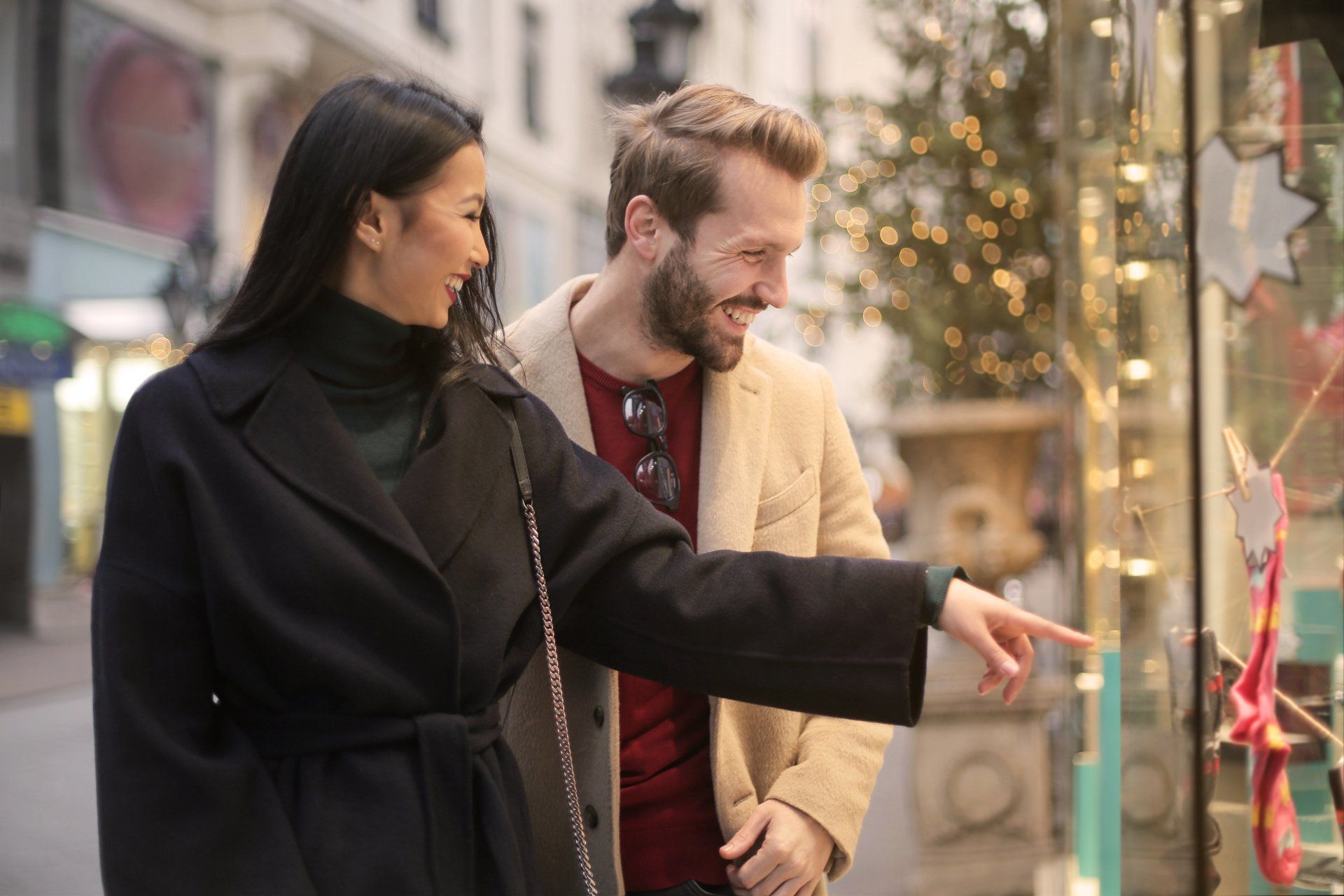 a man and a woman are looking at a store window .