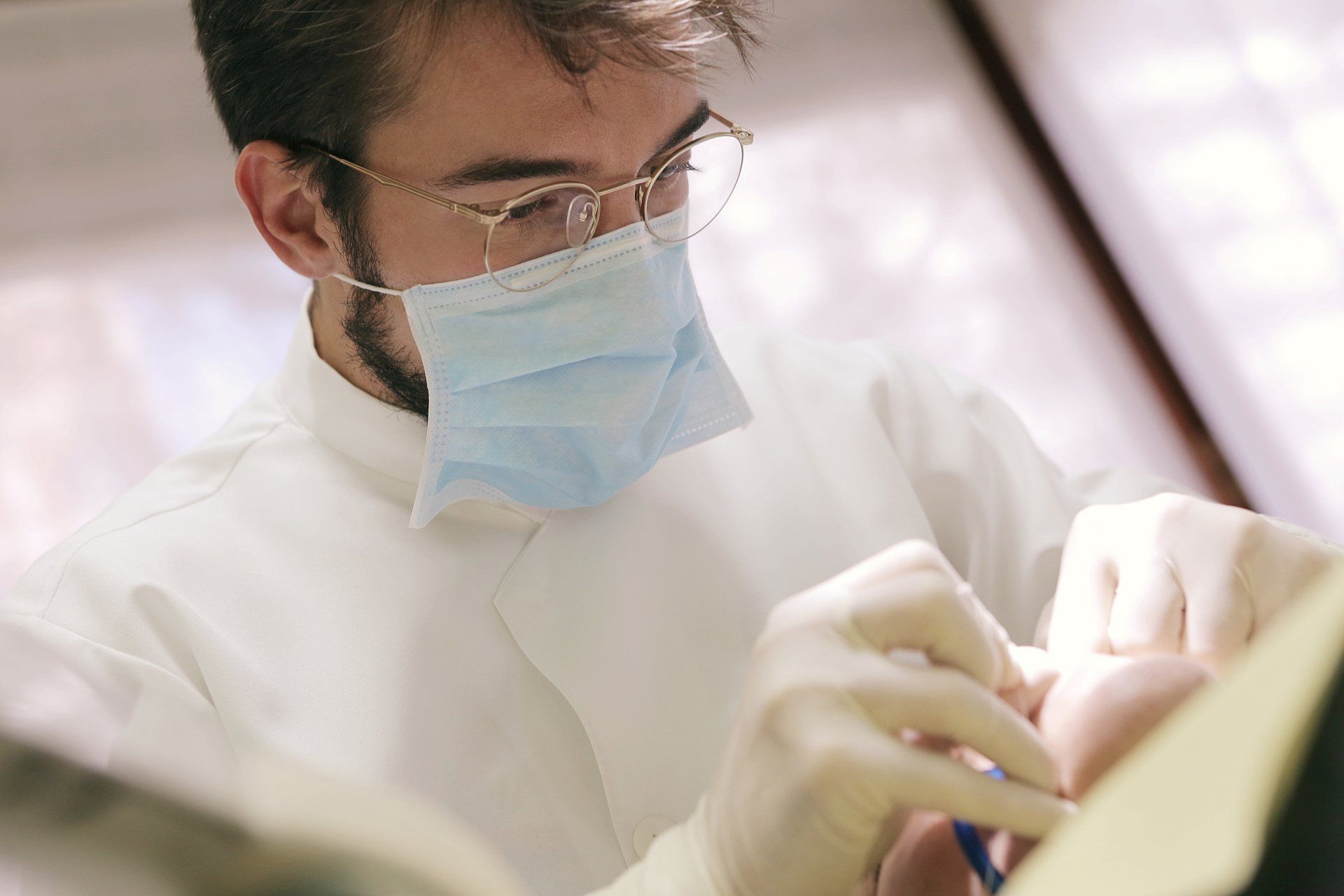 Dentist Hand With Medical Rubber Glove Holding Removable Partial Denture — JCU Dental In Smithfield, QLD