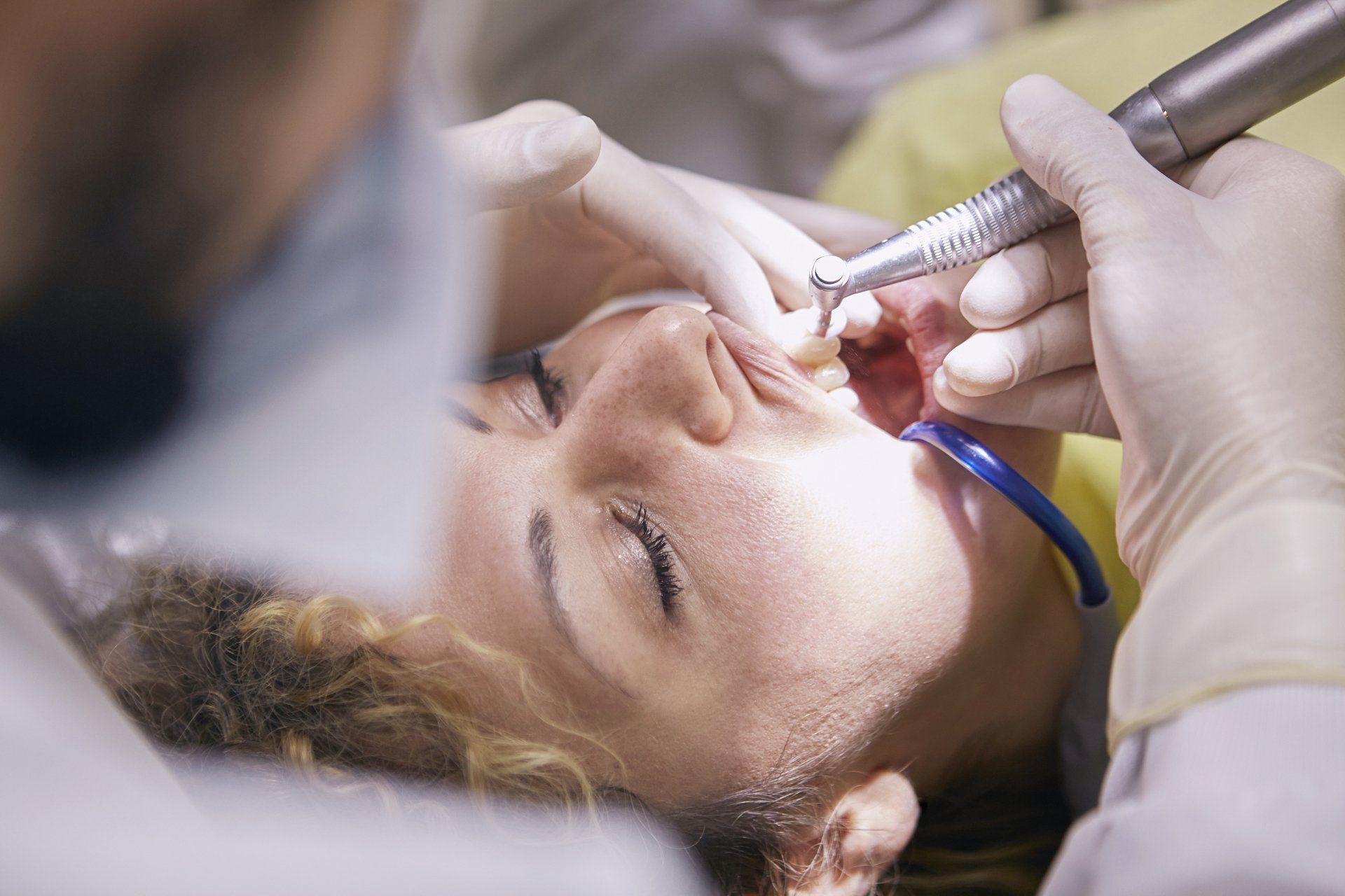 A woman is having her teeth examined by a dentist.