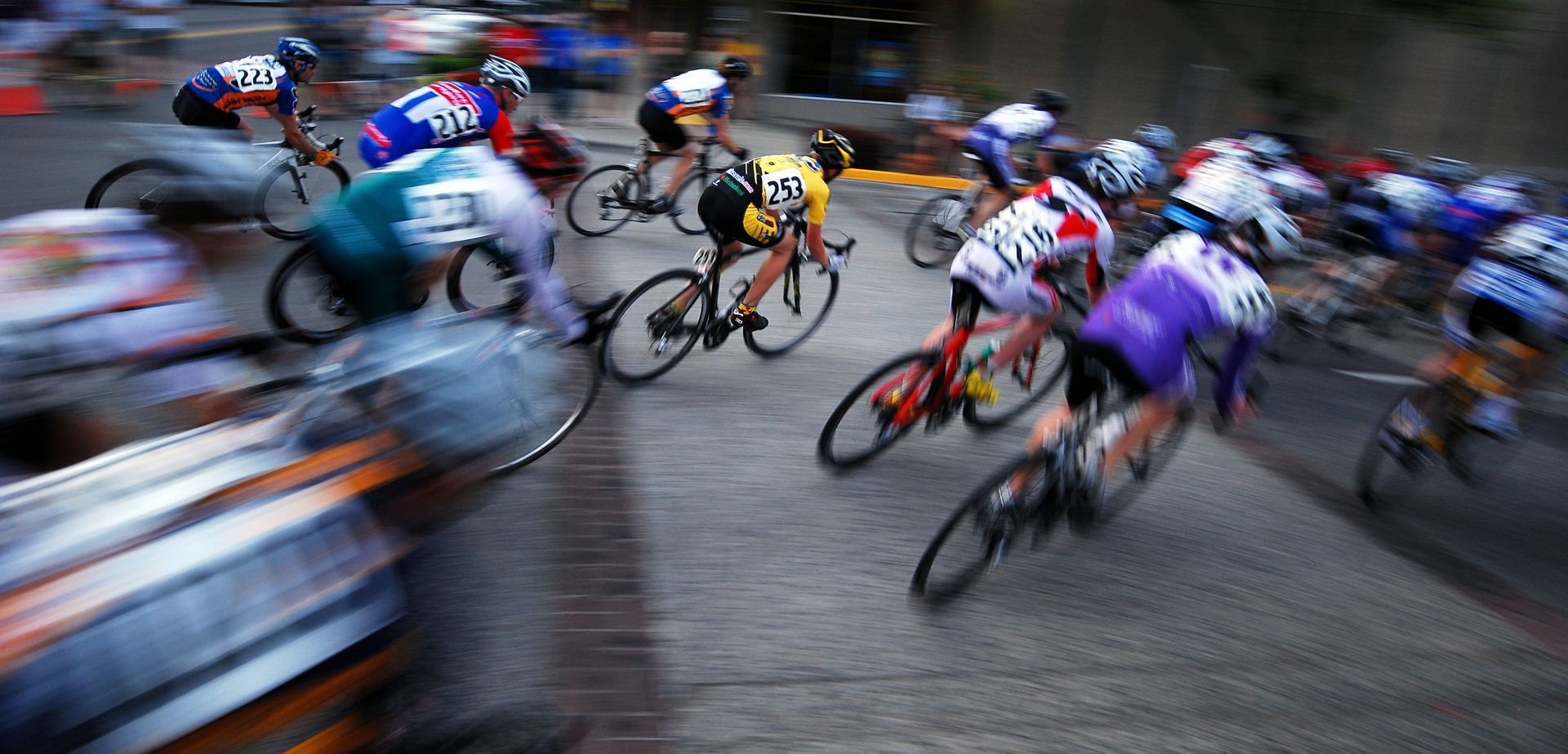 a blurred image of a group of cyclists including number 23 showcasing shutter speed