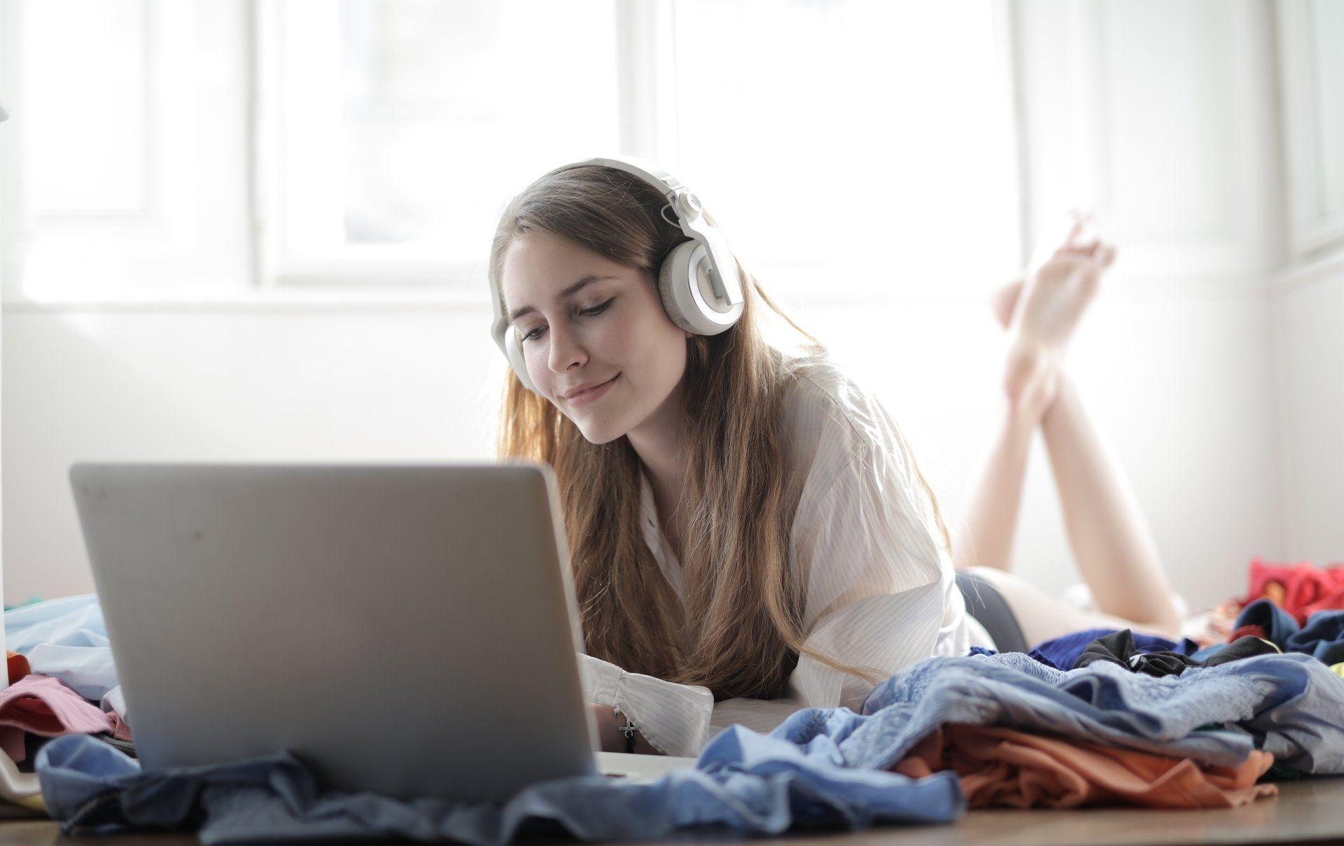  A girl lying on the floor, listening with headphones on