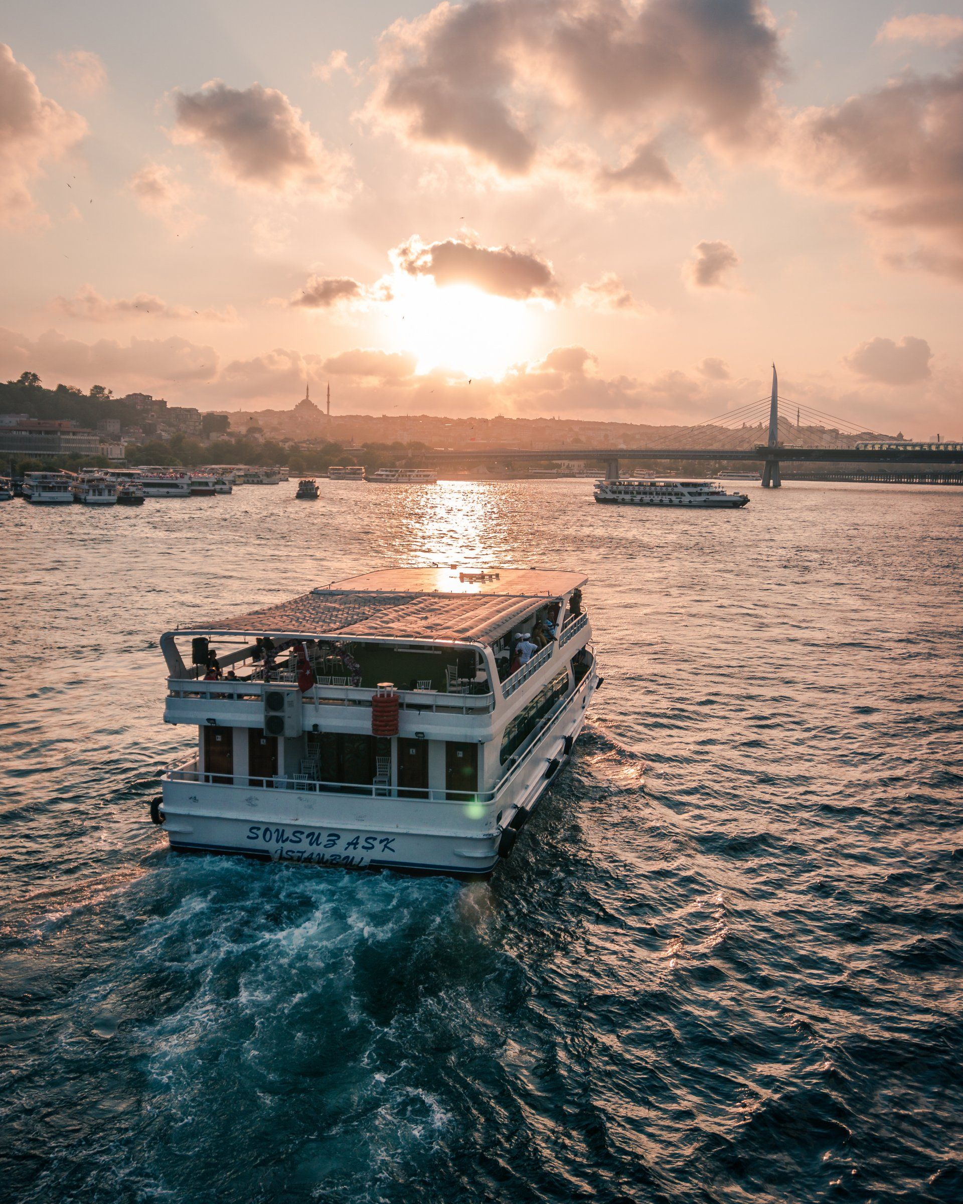 A boat is floating on top of a body of water at sunset.