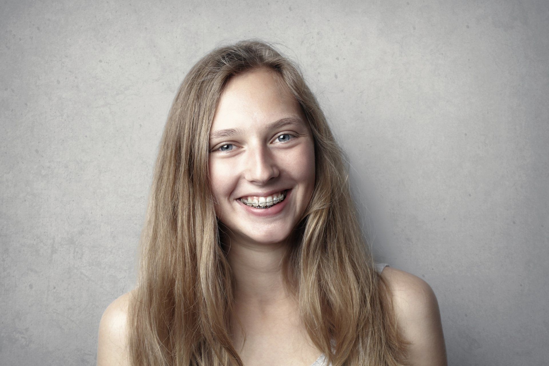 a woman with braces on her teeth smiles for the camera