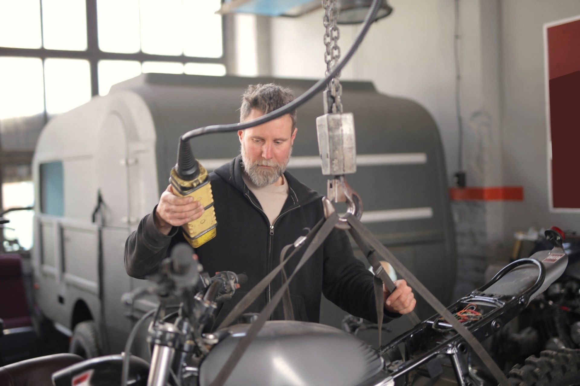 A man is working on a motorcycle in a garage