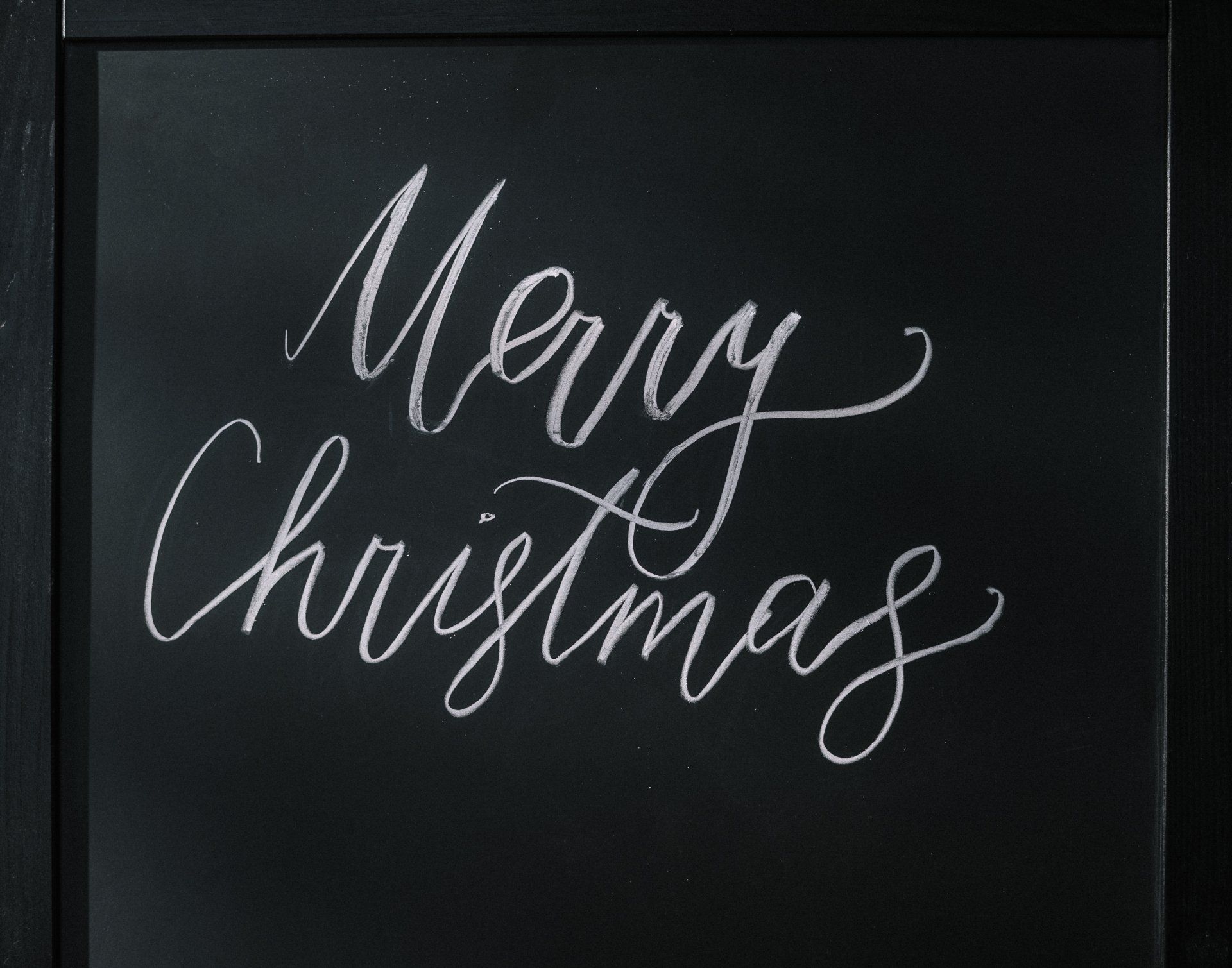 a blackboard with the words merry christmas written on it