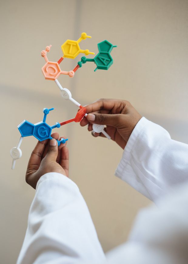 A person is holding a model of a molecule in their hands.