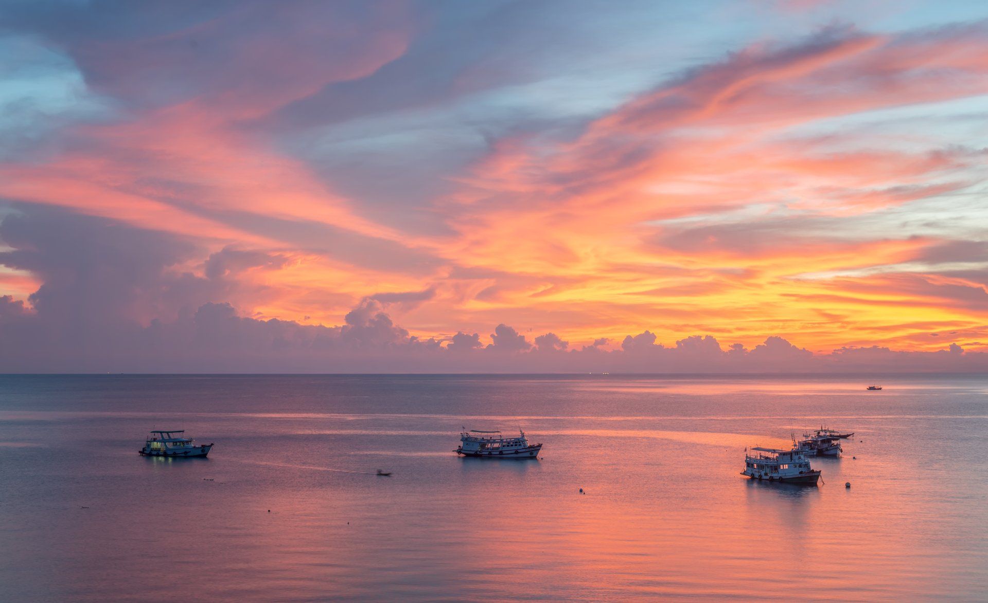 Beautiful lake view at sunset with purple, pink, and golden skies