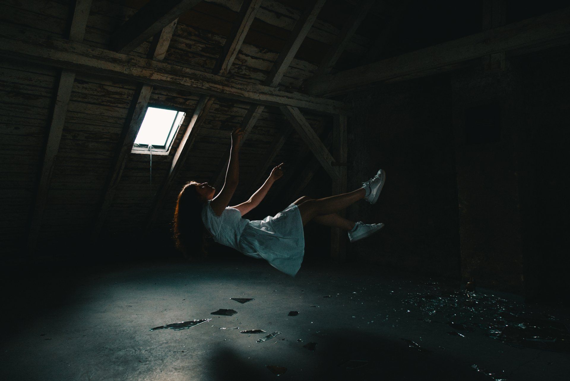 woman in a dress falling backwards in a loft space
