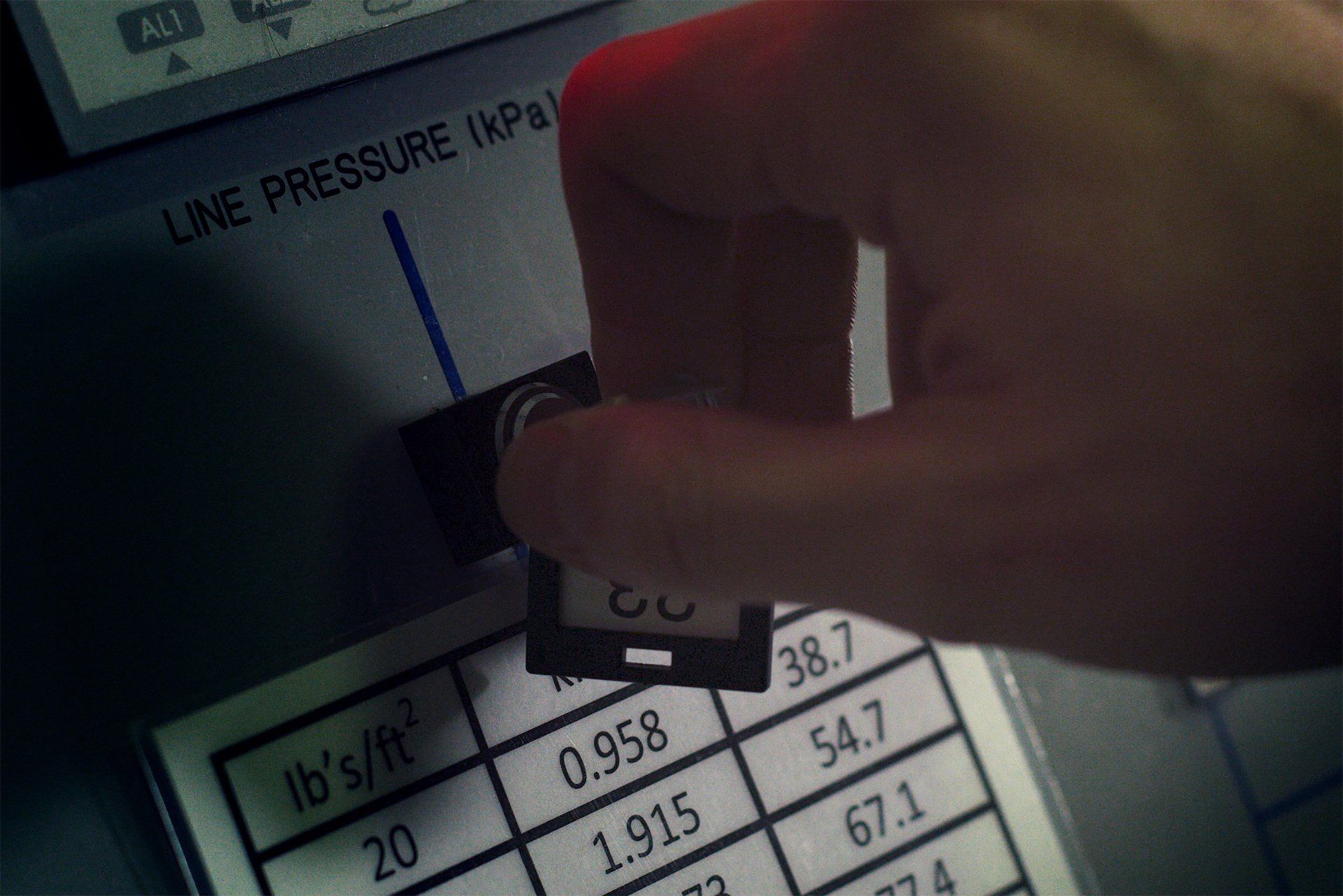 A person is pressing a button that says line pressure