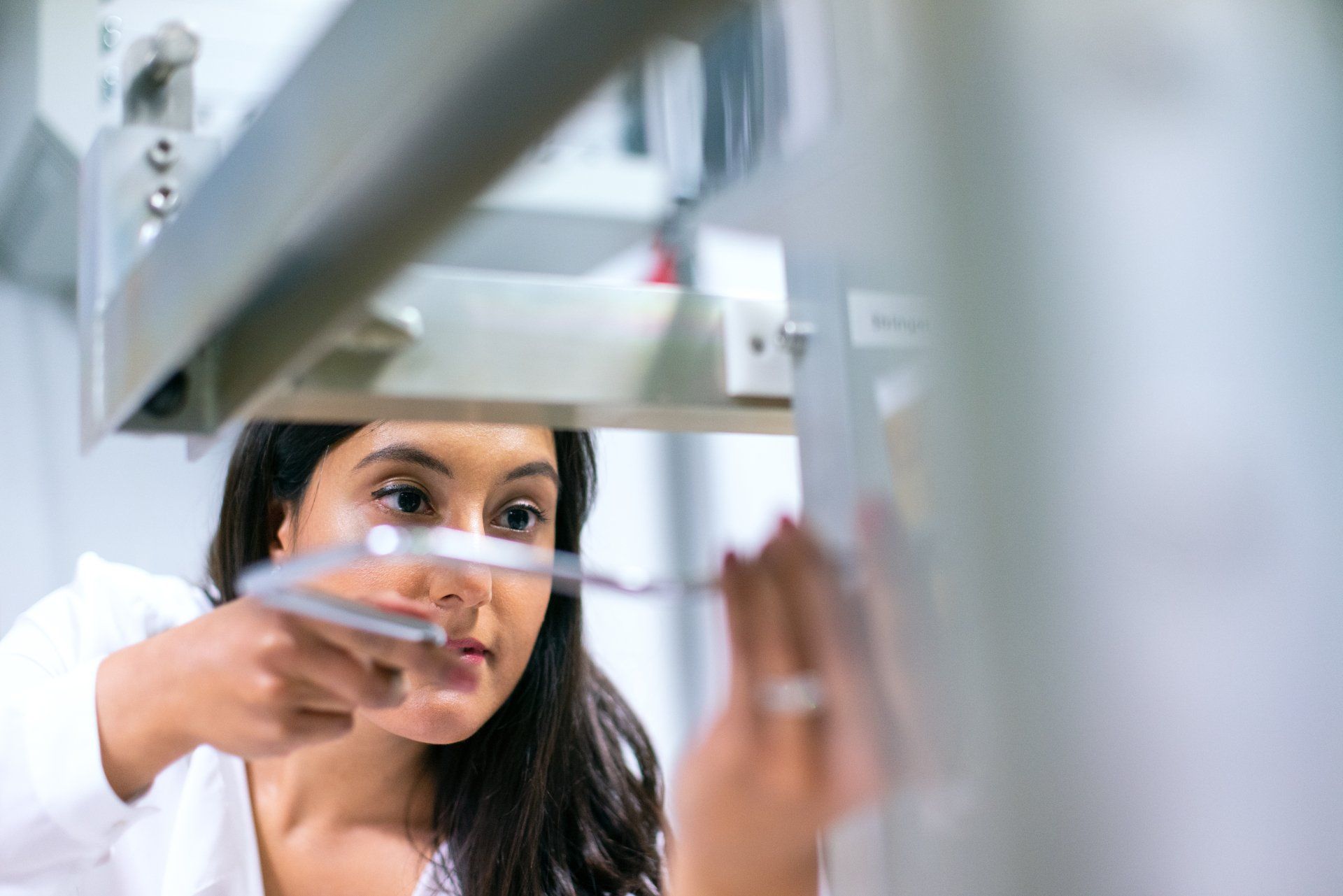 A woman is working on a machine in a laboratory.