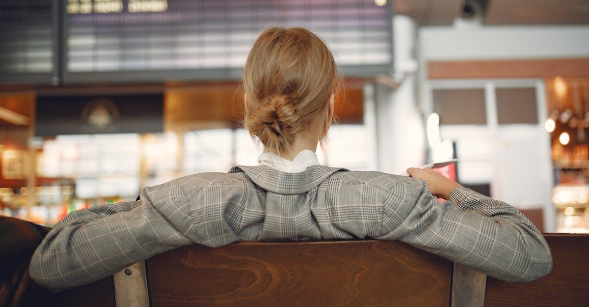 A woman is sitting in an airport waiting for her flight.