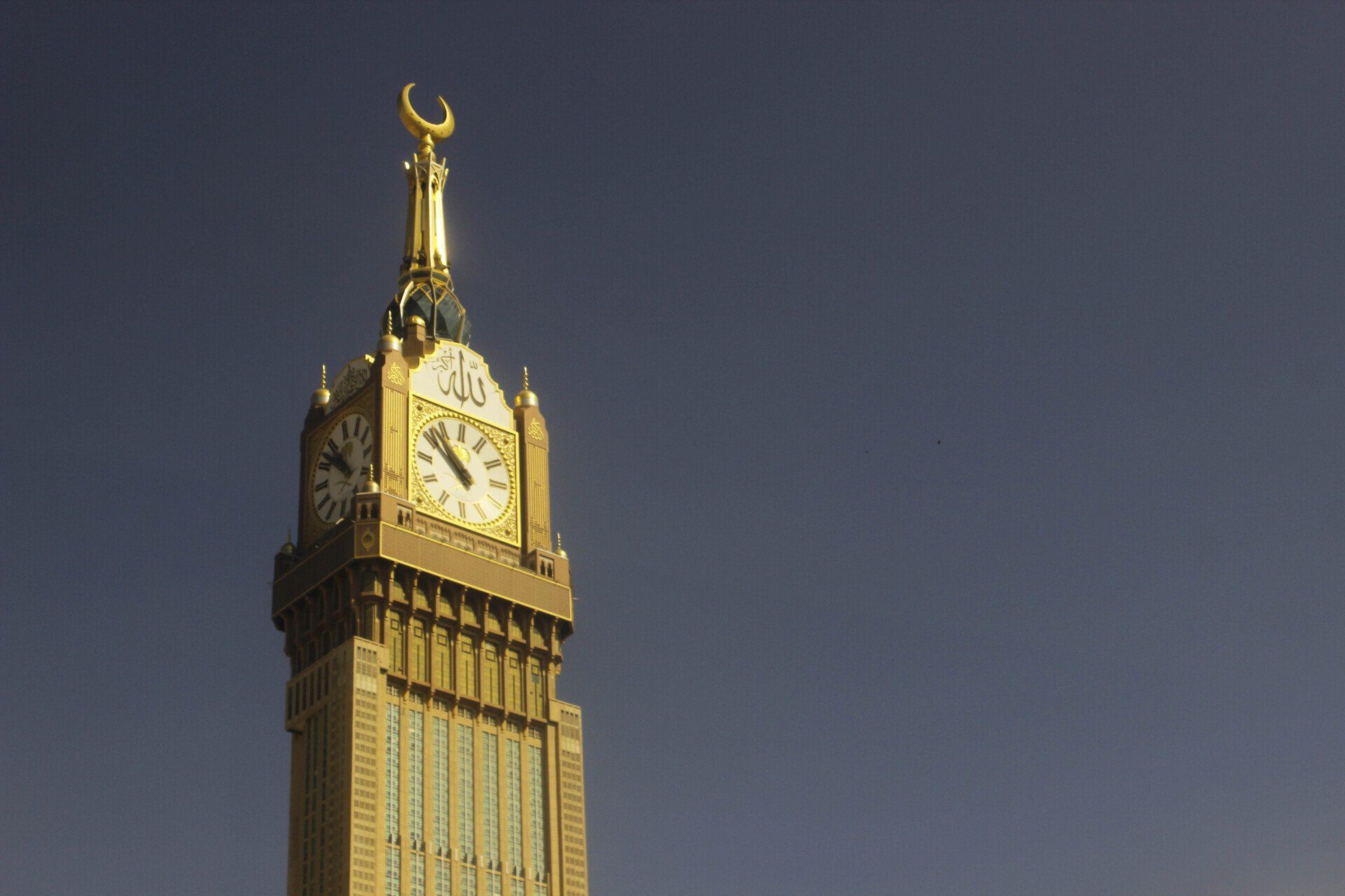 A clock tower with a crescent moon on top of it