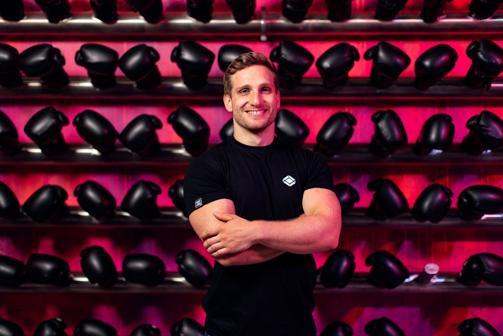 Fitness Profesional standing in front of a shelves full of boxing gloves