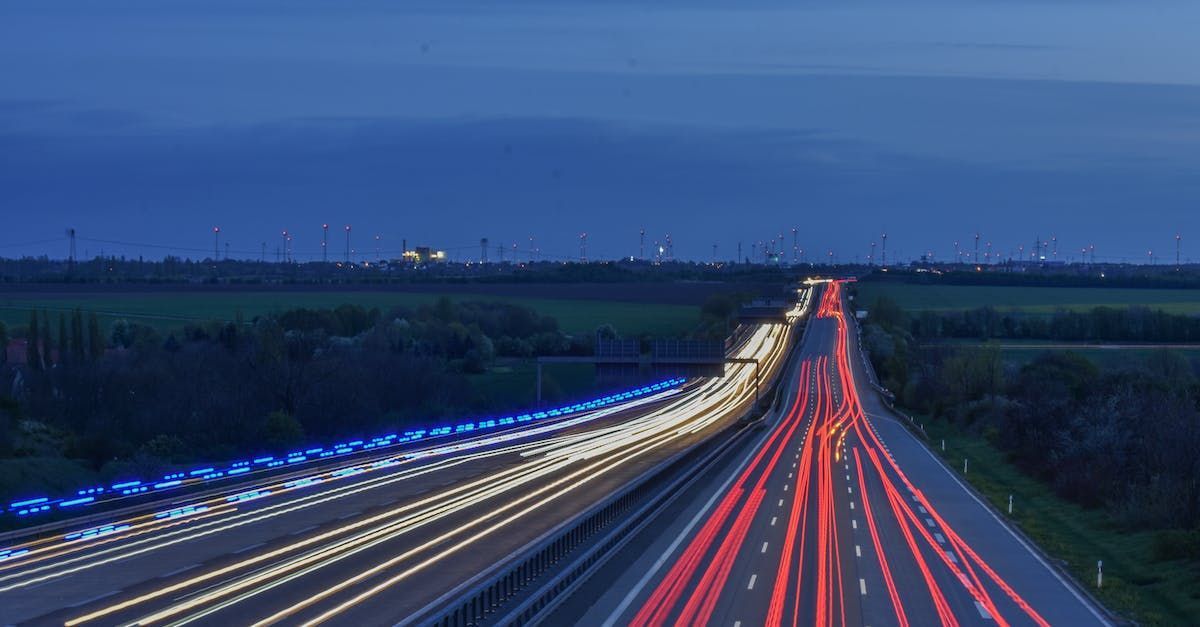 Eine Langzeitbelichtung einer Autobahn bei Nacht mit vielen Lichtspuren.