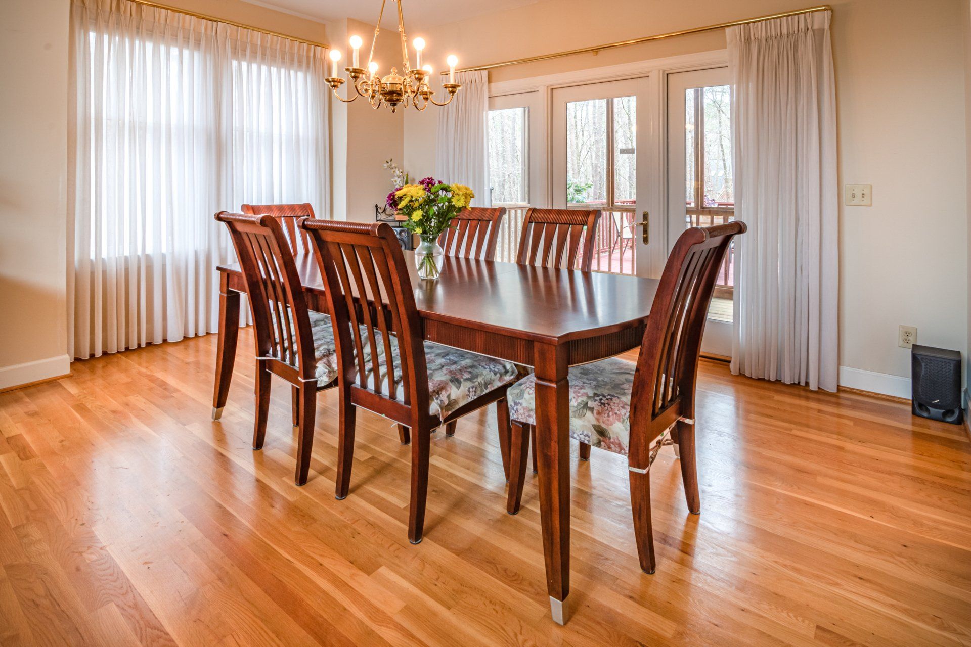 A dining room with a wooden table and chairs on a newly installed hardwood floor