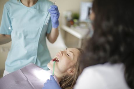 A young girl with braces on her teeth is smiling for the camera.