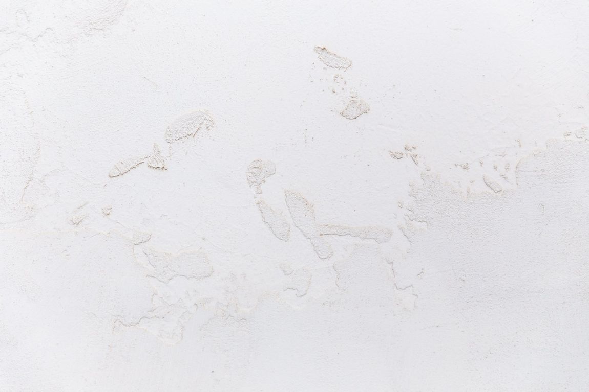 A close up of a white wall with a marble texture.