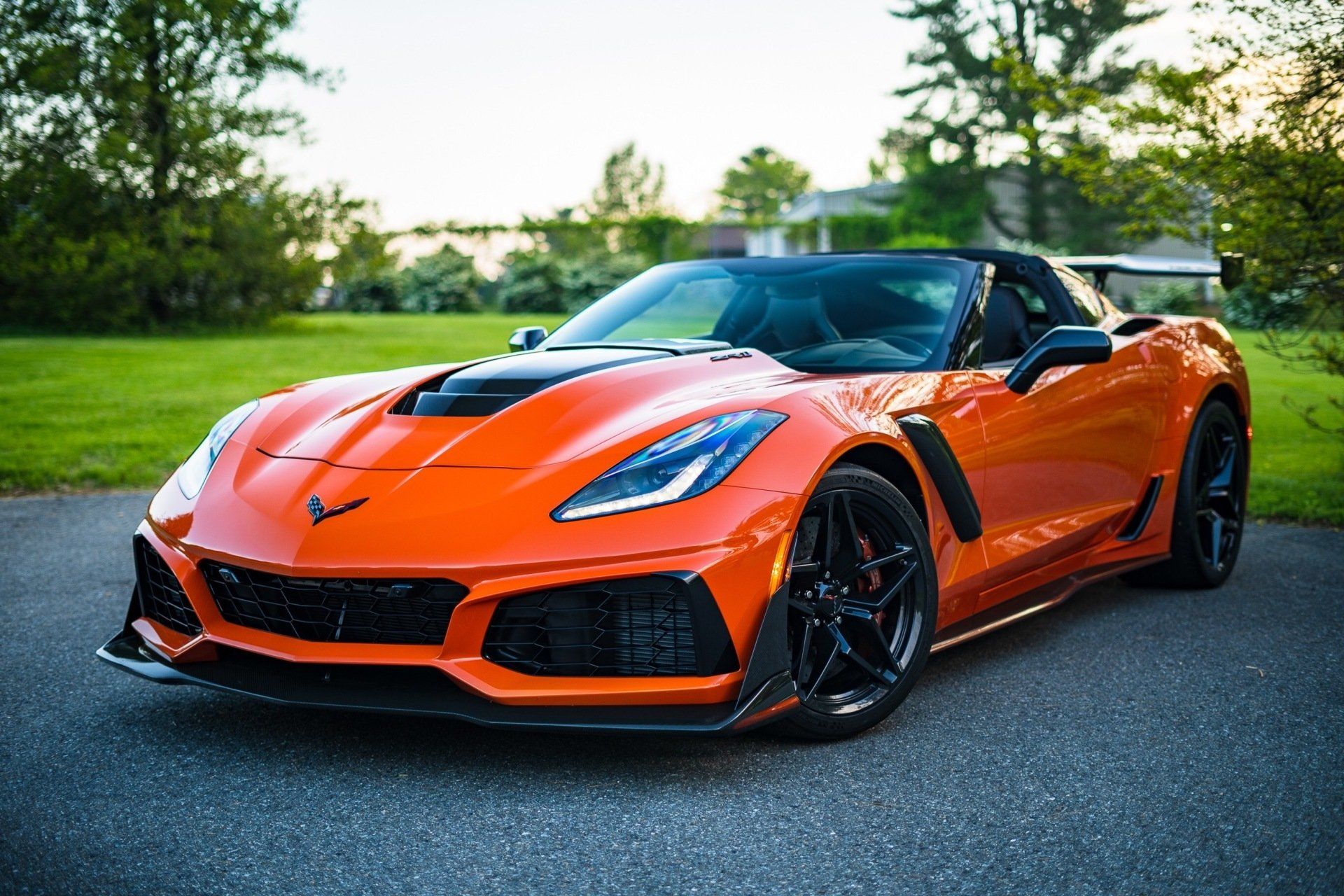 An orange corvette zr1 is parked in a driveway.