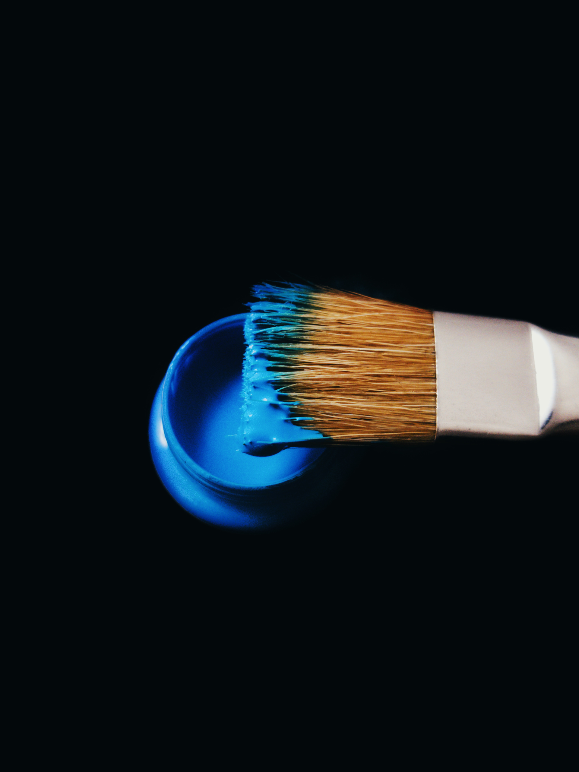 Paintbrush and a pot of blue paint