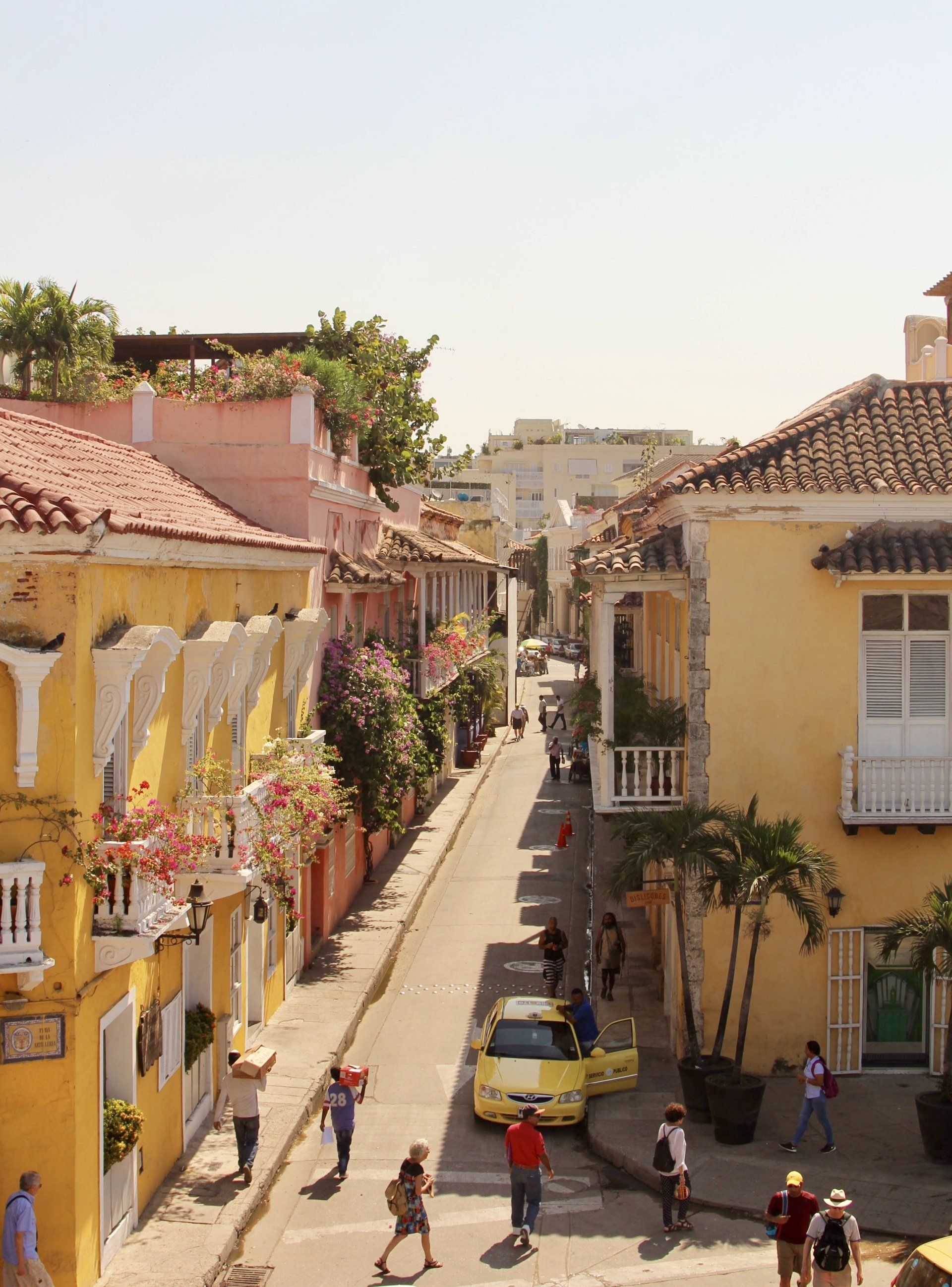 Una vista aérea de una calle estrecha bordeada de edificios amarillos