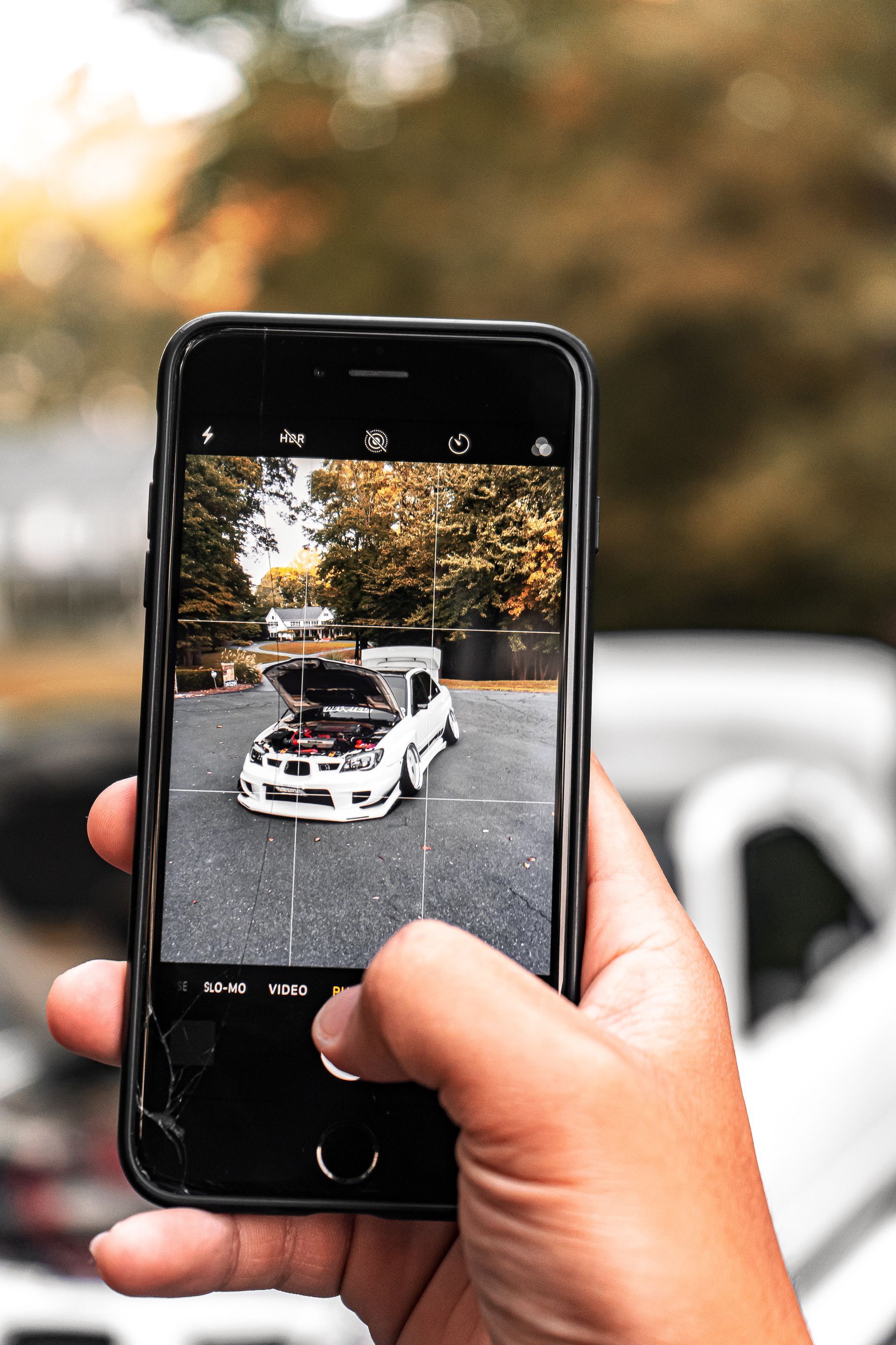 a person is holding a cell phone with a picture of a car on the screen .