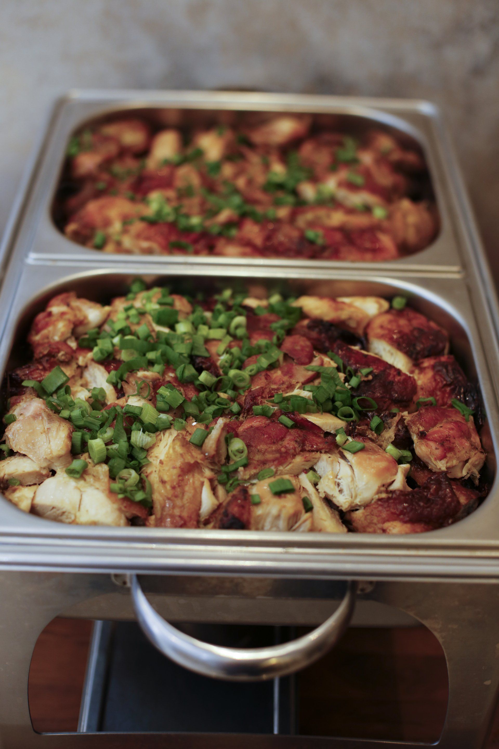 Two trays of food are sitting on a table.