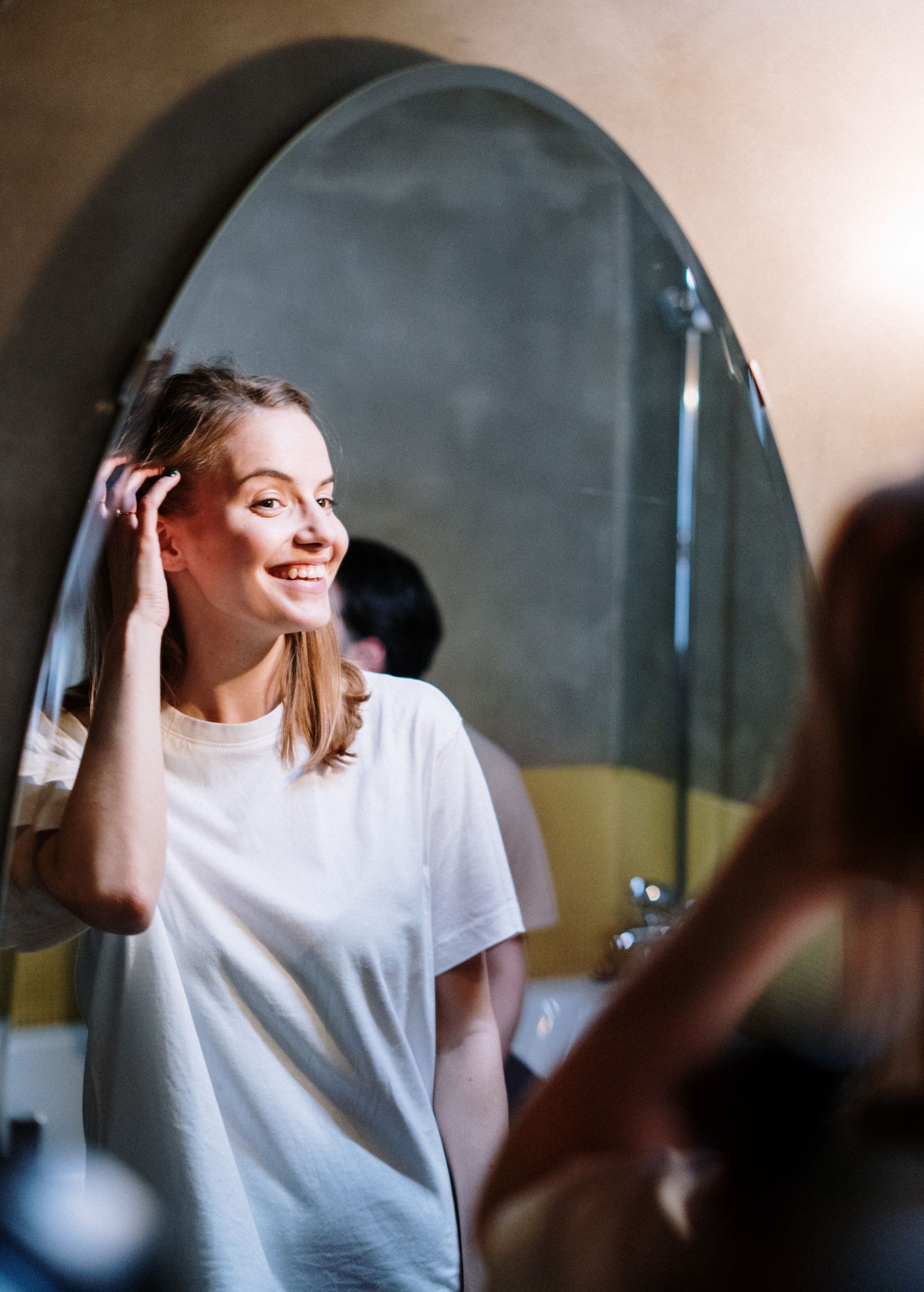 Woman looking at new smile in the mirror