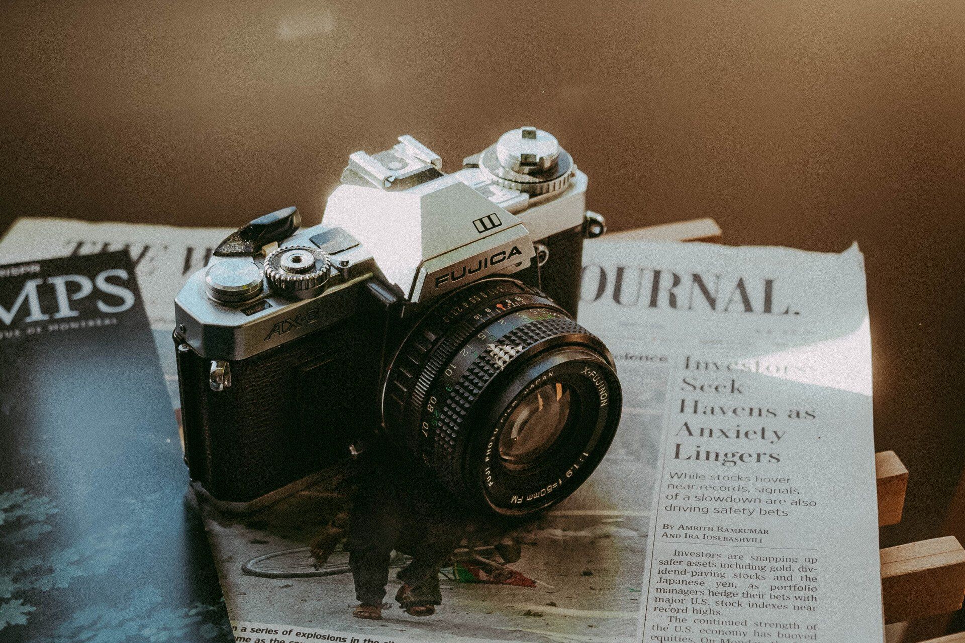 a fujica camera sits on top of a newspaper