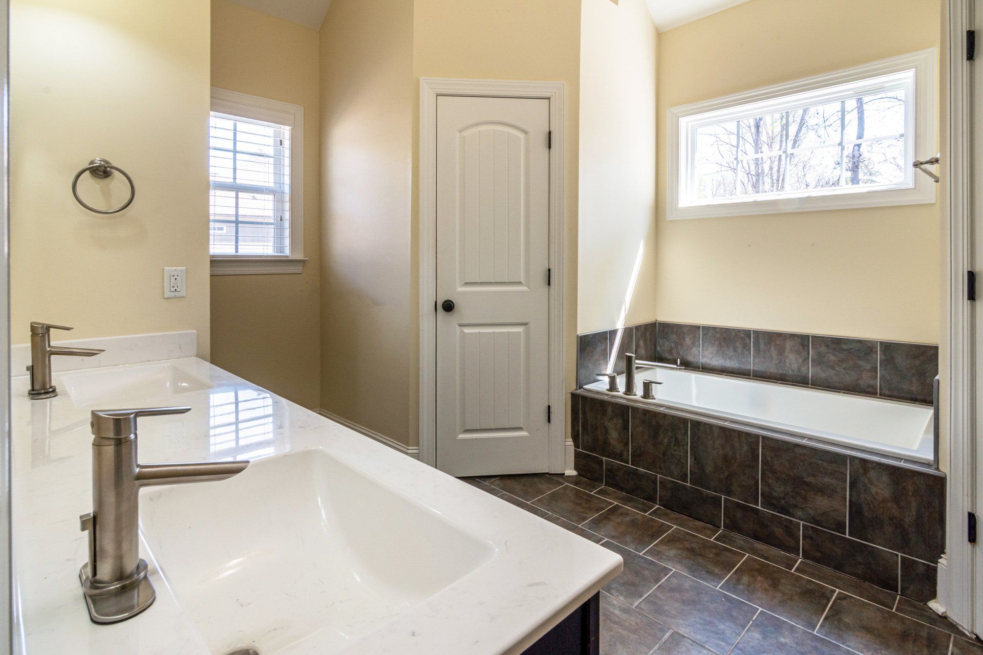 A bathroom with a sink , tub and mirror.