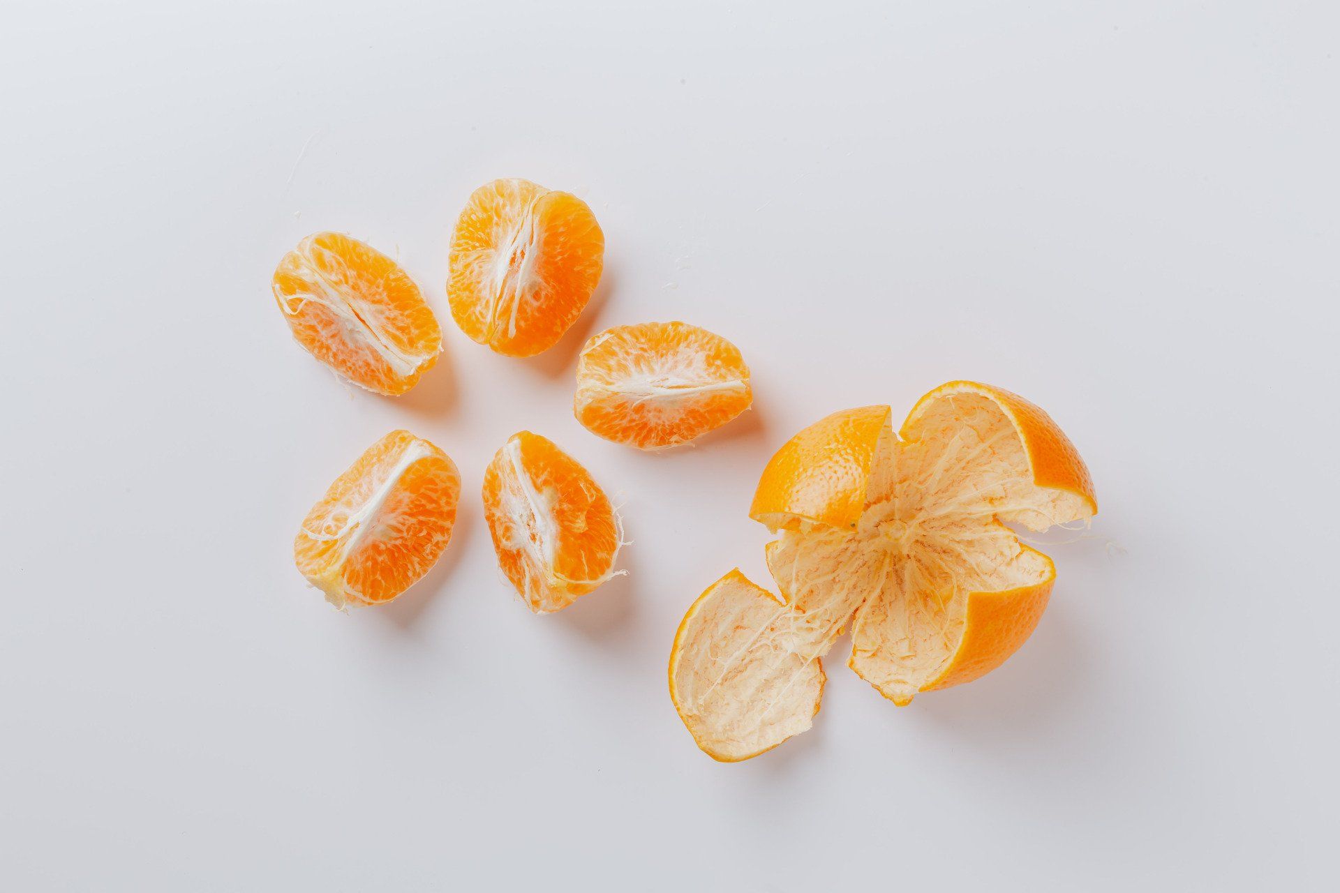 A group of peeled oranges on a white surface.